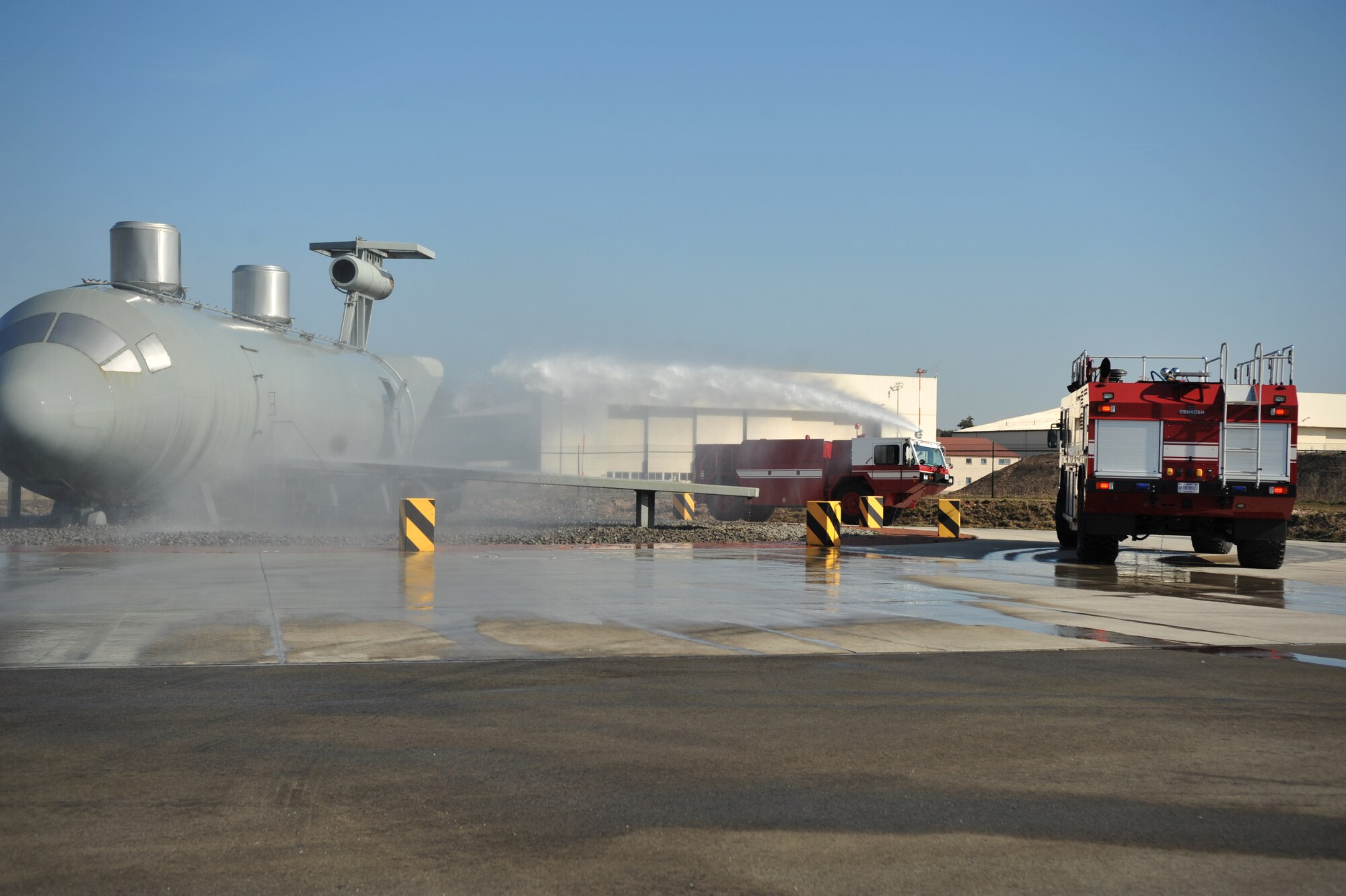 Lithuanian and Bosnian military members use a training aircraft to practice firefighting techniques during the Firefighters Fundamentals Course, March 11, 2014, at Ramstein Air Base, Germany. The course consisted of hands-on simulations and classroom portions allowing service members to learn about different fire rescue techniques. (U.S. Air Force photo/Senior Airman Hailey Haux)