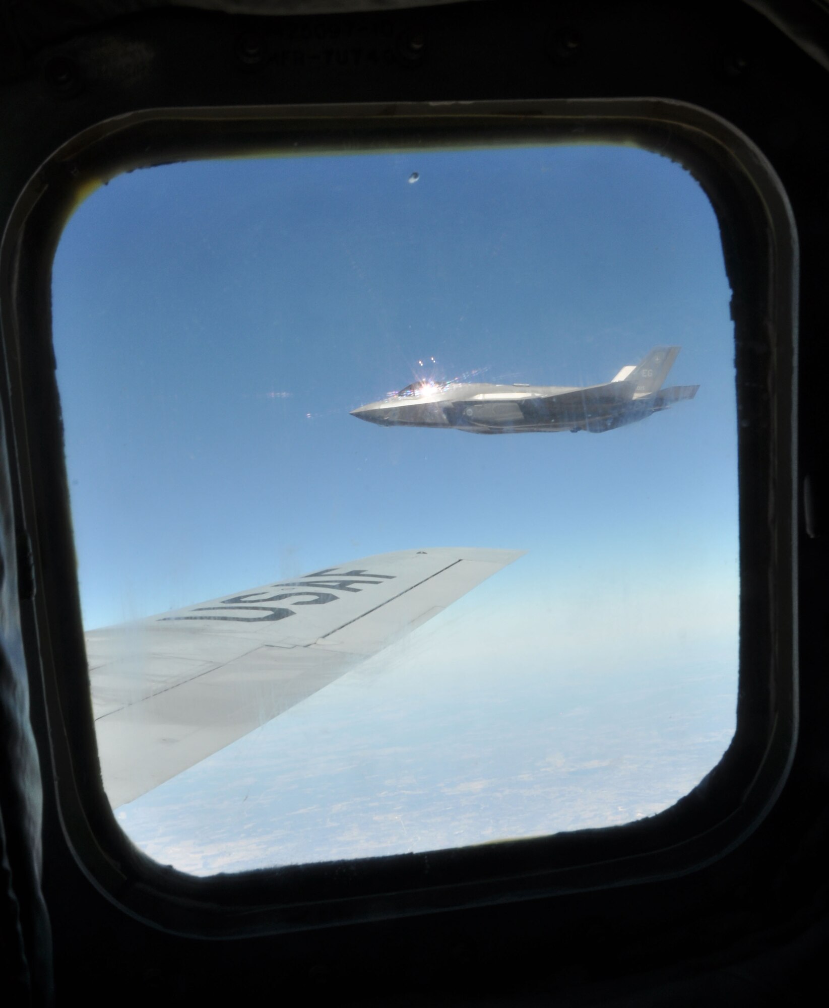 An F-35 Lighting II fighter jet from the 33rd Fighter Wing, Eglin Air Force Base, Fla., flies over the wingtip of a KC-135 Stratotanker from the 459th Air Refueling Wing, Joint Base Andrews, Md., over the plains of Texas, March 12, 2014. The tanker met with the fighter jet at 27,000 feet in the air for an aerial refueling mission. (U.S. Air Force photo/ Staff Sgt. Katie Spencer)