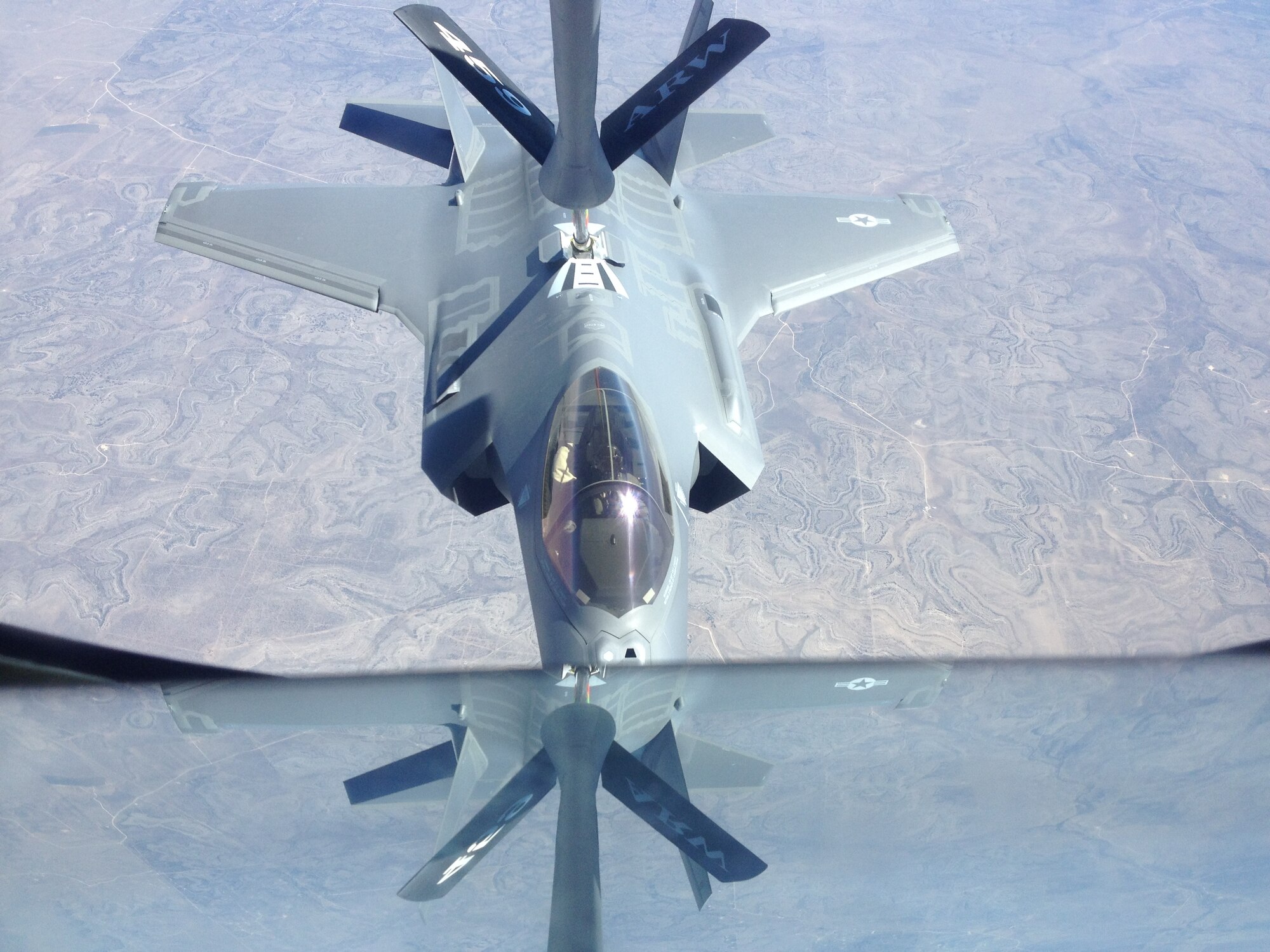 An F-35 Lighting II fighter jet from the 33rd Fighter Wing, Eglin Air Force Base, Fla., gets refueled by a KC-135 Stratotanker from the 459th Air Refueling Wing, Joint Base Andrews, Md., over the plains of Texas, March 12, 2014. The tanker met with the fighter jet at 27,000 feet in the air for an aerial refueling mission. (U.S. Air Force photo/ Staff Sgt. Katie Spencer)