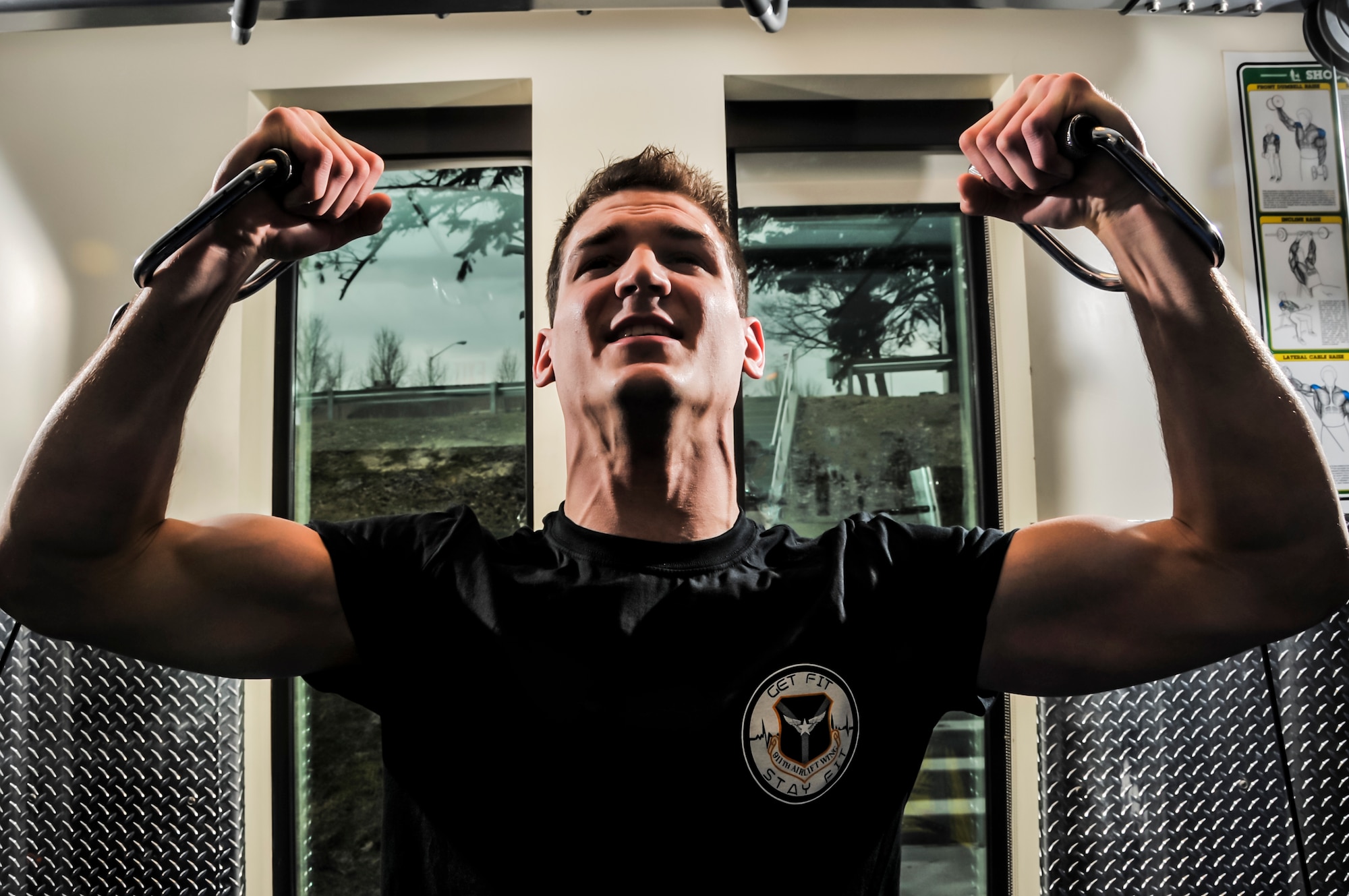 Senior Airman Ty Albright, 911th Services Squadron morale welfare and recreation specialist, performs an overhead cable curl on the cable crossover machine at the Pittsburgh International Airport Air Reserve Station fitness center, March 20, 2014. As a way of promoting health and wellness, the fitness center hands out “Get fit, Stay fit” t-shirts at their fitness promotional events. For information on exercise classes offered contact the fitness center at (412) 474-8245. (U.S. Air Force photo by Senior Airman Joshua J. Seybert)