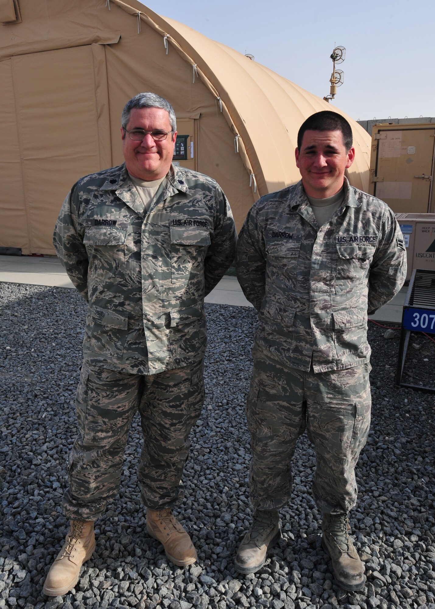 Air Force Lt. Col. Christopher Darrow and Air Force Airman 1st Class Stephen Darrow, 727th Expeditionary Air Control Squadron, pose for a photo together at an undisclosed location in Southwest Asia, March 20, 2014. (U.S. Air Force photo by Staff Sgt. Michael Means/Released)