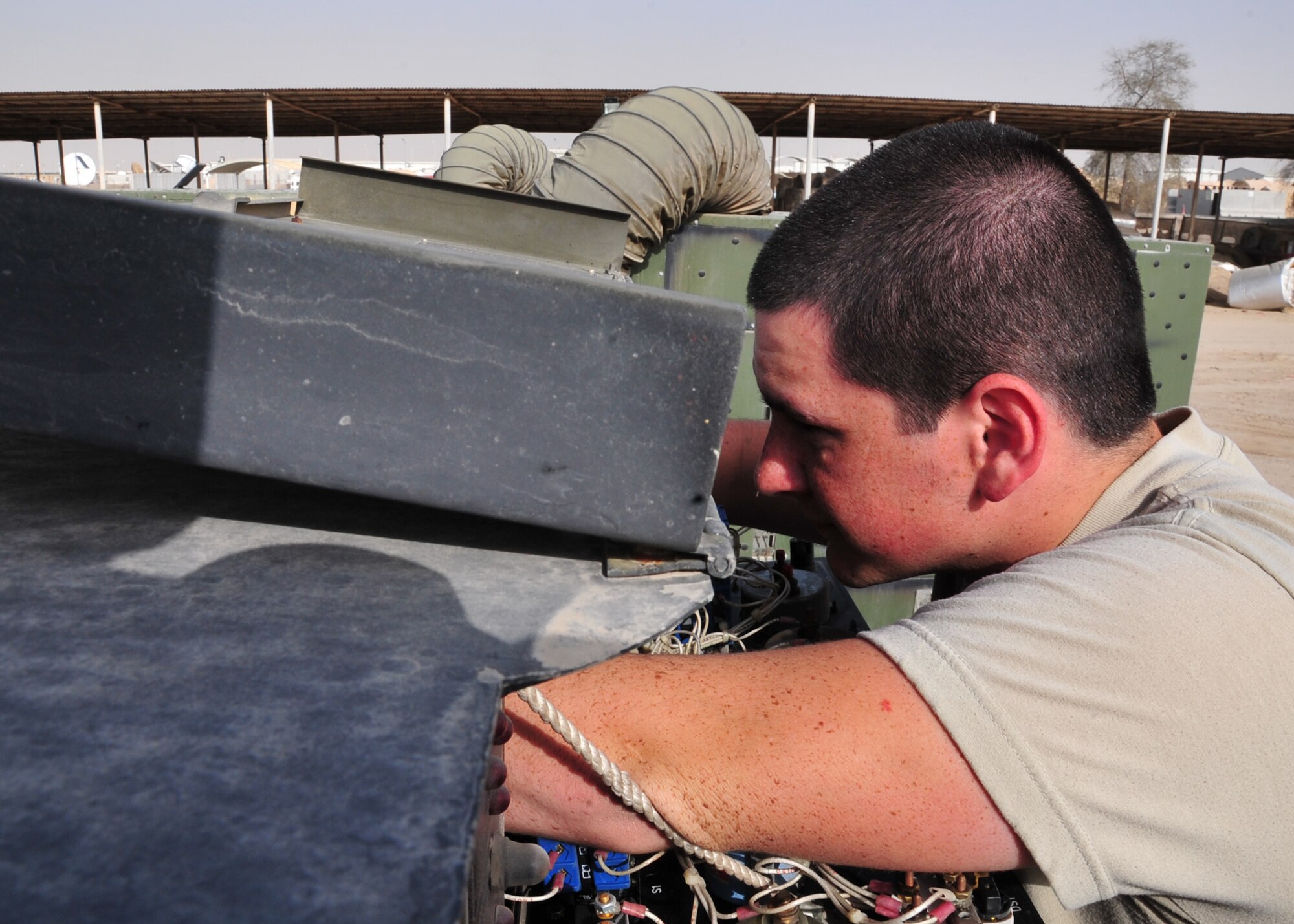 Airman 1st Class Stephen Darrow, 727th Expeditionary Air Control Squadron Air Ground Equipment journeyman, works on a generator at an undisclosed location in Southwest Asia, March 20, 2014. (U.S. Air Force photo by Staff Sgt. Michael Means/Released)