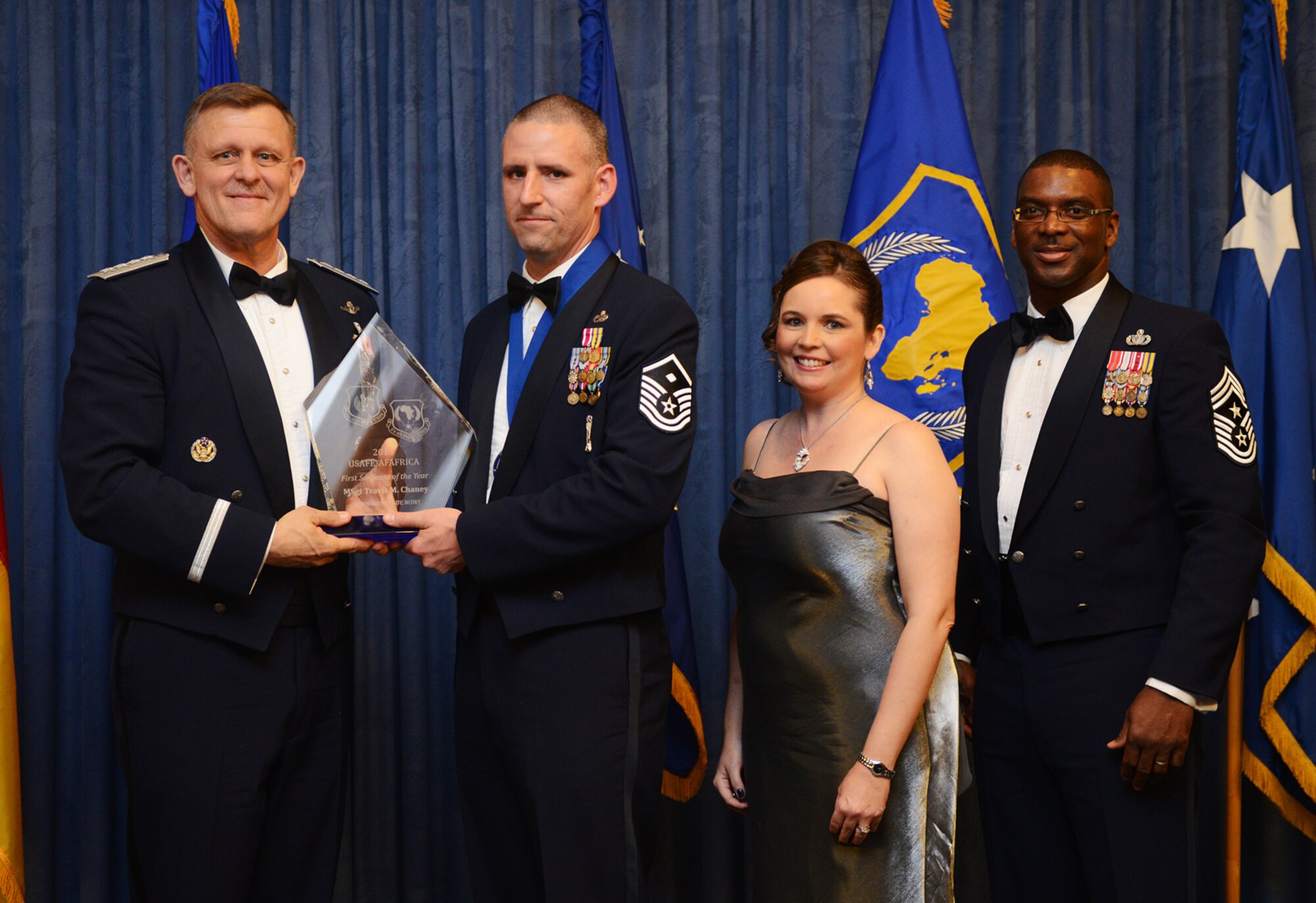 Master Sgt. Travis Chaney, 65th Medical Group first sergeant receives his U.S. Air Forces in Europe and Air Forces Africa First Sergeant of the Year award from Gen. Frank Gorenc, USAFE-AFAFRICA commander and Chief Master Sgt. James E. Davis, USAFE-AFAFRICA command chief, during an annual awards ceremony at Ramstein Air Base Germany March 20, 2014. The Airmen competed within their units, then at the wing level and have now been named the best in USAFE-AFAFRICA. They will go on to compete at the Air Force level for the coveted Outstanding Airmen of the Year award which will be announced later this year.  (U.S. Air Force photo/ Staff Sgt. Ryan Crane)