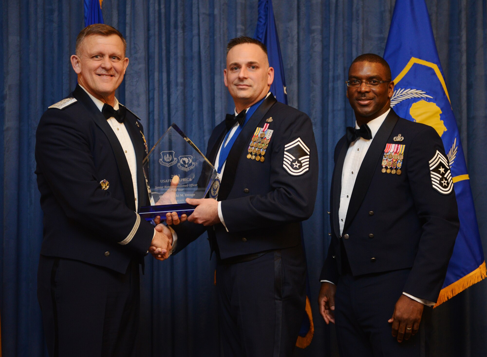 Senior Master Sgt.  Nikki Drago, 423rd Security Forces Squadron enlisted manager, receives his U.S. Air Forces in Europe and Air Forces Africa Senior NCO of the Year award from Gen. Frank Gorenc, USAFE-AFAFRICA commander and Chief Master Sgt. James E. Davis, USAFE-AFAFRICA command chief, during an annual awards ceremony at Ramstein Air Base Germany March 20, 2014. The Airmen competed within their units, then at the wing level and have now been named the best in USAFE-AFAFRICA. They will go on to compete at the Air Force level for the coveted Outstanding Airmen of the Year award which will be announced later this year.  (U.S. Air Force photo/ Staff Sgt. Ryan Crane)