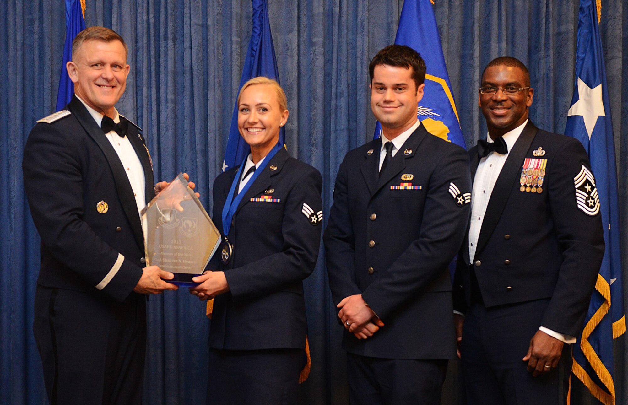 Senior Airman Shabree Heasell, 603rd Air Operations Center training and tactics technician, receives her U.S. Air Forces in Europe-Air Forces Africa Airman of the Year award from Gen. Frank Gorenc, USAFE-AFAFRICA commander and Chief Master Sgt. James E. Davis, USAFE-AFAFRICA command chief, during an annual awards ceremony at Ramstein Air Base Germany March 20, 2014. Airmen competed within their units, then at the wing level and have now been named the best in USAFE-AFAFRICA. They will go on to compete at the Air Force level for the coveted Outstanding Airmen of the Year award which will be announced later this year. (U.S. Air Force photo/ Staff Sgt. Ryan Crane)