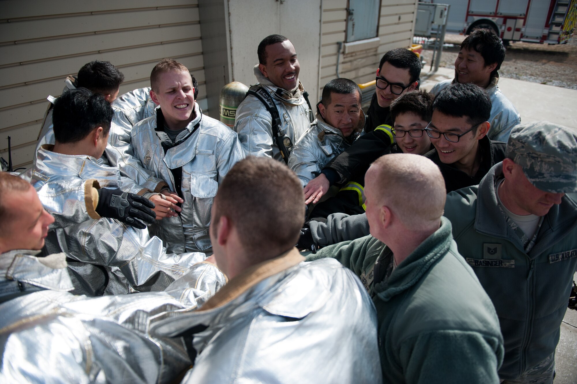 Firefighters from the 8th Civil Engineer Squadron, the Republic of Korea air force 38th Fighter Group and Marine Wing Support Squadron 172 celebrate after completing their training at Kunsan Air Base, Republic of Korea, Mar. 18, 2014. The 8th CES fire department conducted classroom and live-fire training with firefighters from Marine Wing Support Squadron 172 and the RoKaf 38th Fighter Group fire department to enhance teamwork between fire departments. (U.S. Air Force photo by Staff Sgt. Clayton Lenhardt/Released)