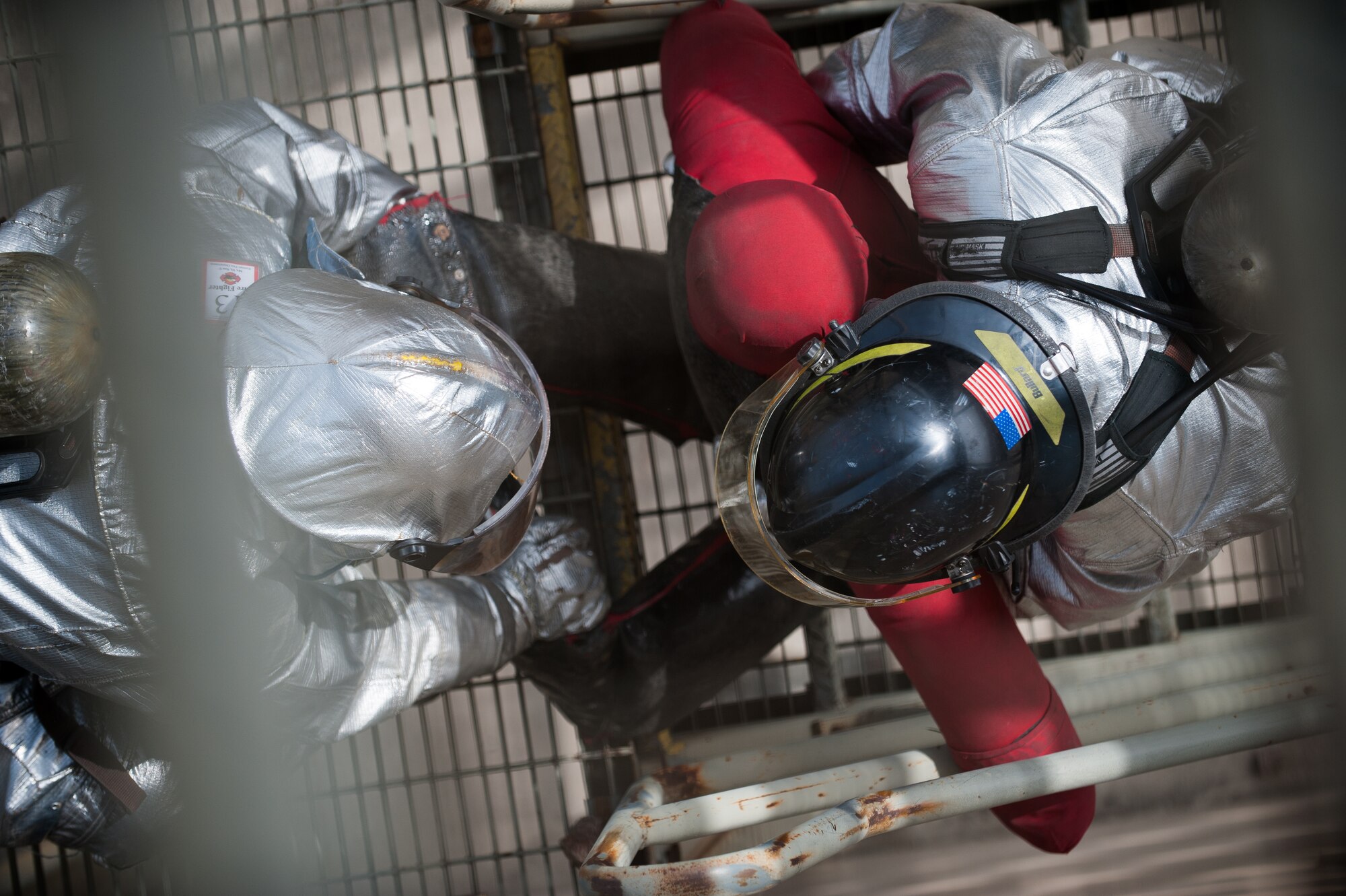 Yi, Son U, left and Staff Sgt. Jared Robinson, right, 8th Civil Engineer Squadron firefighters, carry a dummy down a flight of stairs during an exercise at Kunsan Air Base, Republic of Korea, Mar. 18, 2014. The 8th CES fire department conducted classroom and live-fire training with firefighters from Marine Wing Support Squadron 172 and the Republic of Korea air force 38th Fighter Group fire department to enhance teamwork between fire departments. (U.S. Air Force photo by Staff Sgt. Clayton Lenhardt/Released)