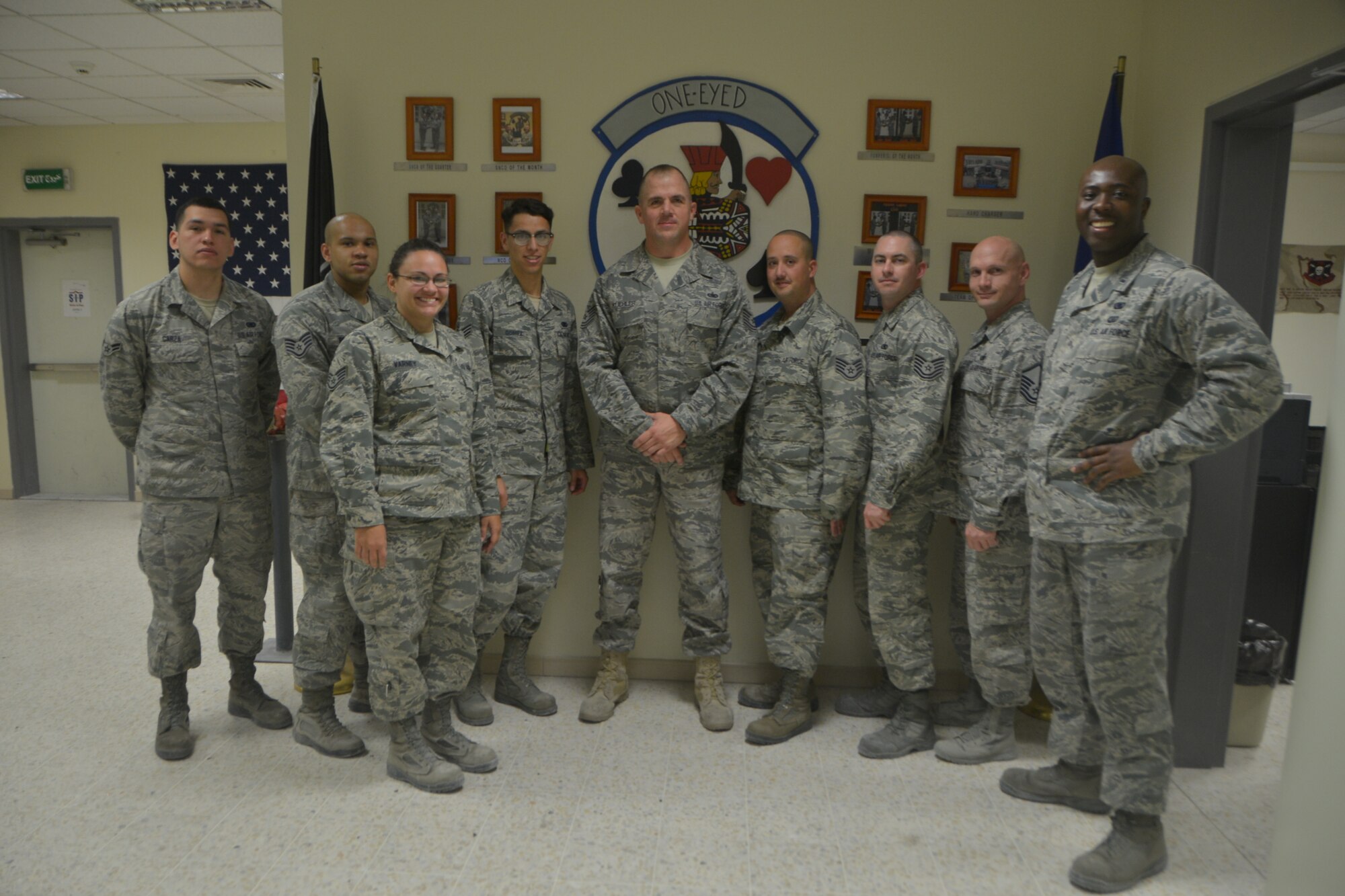 Tech. Sgt. Michael Kuehler (center), poses for a group photo with his fellow fuels Airmen at Al Udeid Air Base, Qatar, Mar. 18, 2014. Kuehler is part of the Air Force Reserve and is deployed here working as a fuels operations supervisor providing fuel to military aircraft. Kuehler also wears a police officer uniform working as a patrol officer in the Phoenix Police Department where he serves his local community. Kuehler is assigned to the 379th Expeditionary Logistics Readiness Squadron Fuels Flight and is deployed from Luke Air Force Base, Ariz. and a Morton, Texas native. (U.S. Air Force photo/Senior Airman Jared Trimarchi) 