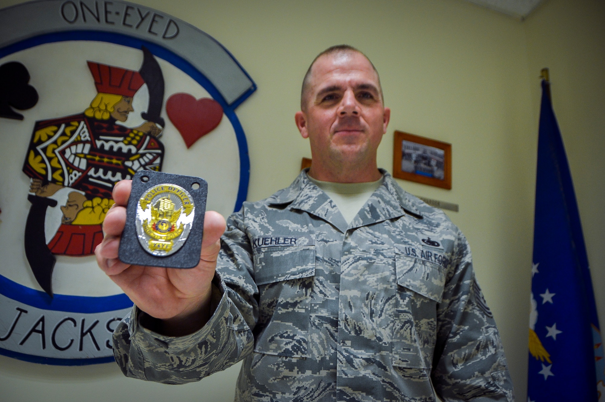 Tech. Sgt. Michael Kuehler, holds his police officer badge at Al Udeid Air Base, Qatar, Mar. 18, 2014. Kuehler is part of the Air Force Reserve and is deployed here working as a fuels operations supervisor providing fuel to military aircraft. Kuehler also wears a police officer uniform working as a patrol officer in the Phoenix Police Department where he serves his local community. Kuehler is assigned to the 379th Expeditionary Logistics Readiness Squadron Fuels Flight and is deployed from Luke Air Force Base, Ariz. and a Morton, Texas native. (U.S. Air Force photo/Senior Airman Jared Trimarchi) 