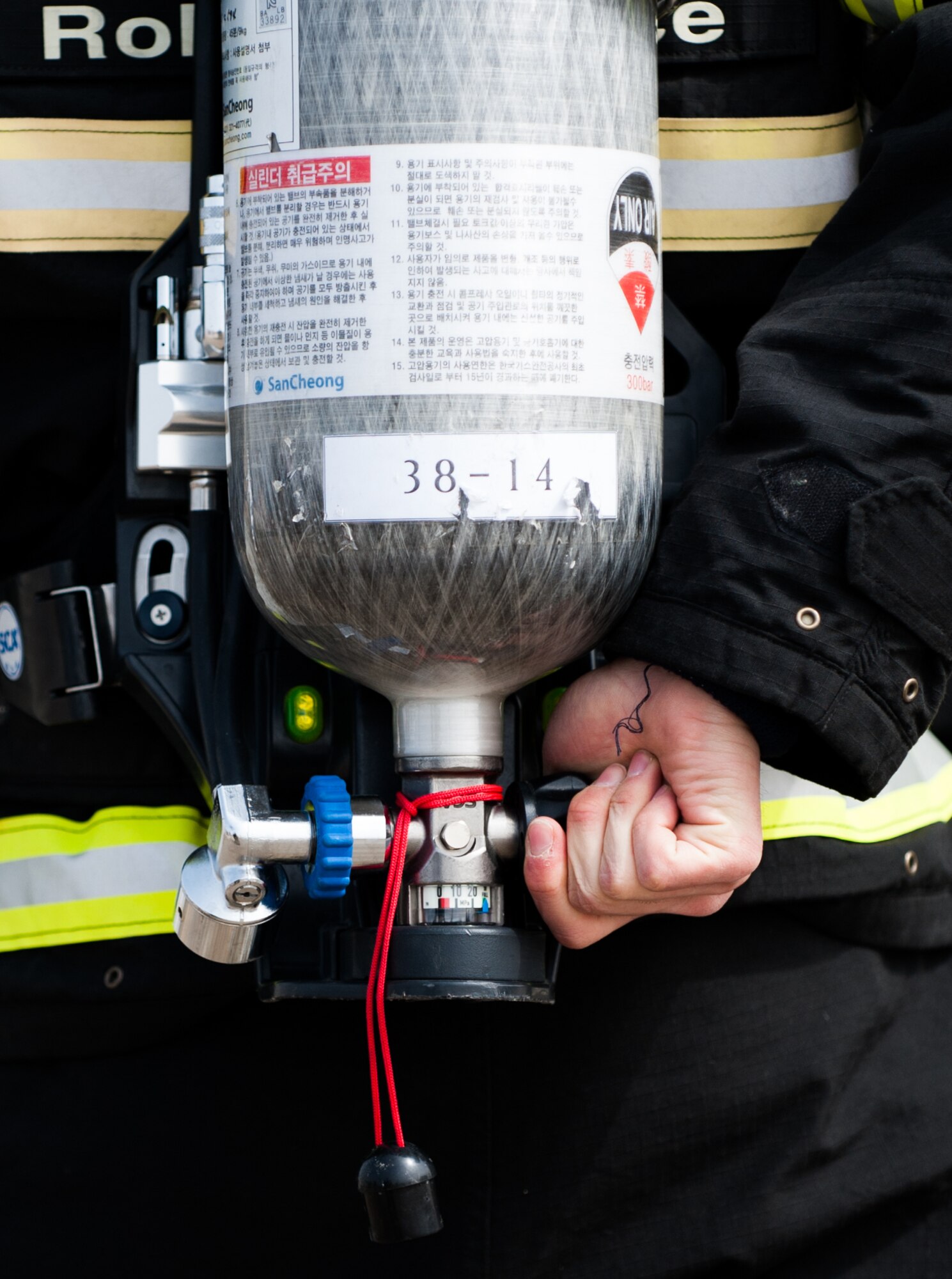 A Republic of Korea air force 38th Fighter Group firefighter adjusts his oxygen tank before responding to a simulated fire at Kunsan Air Base, Republic of Korea, Mar. 18, 2014. The 8th Civil Engineer Squadron fire department conducted classroom and live-fire training with firefighters from Marine Wing Support Squadron 172 and the RoKaf 38th Fighter Group fire department to enhance the teamwork between fire departments. (U.S. Air Force photo by Staff Sgt. Clayton Lenhardt/Released)