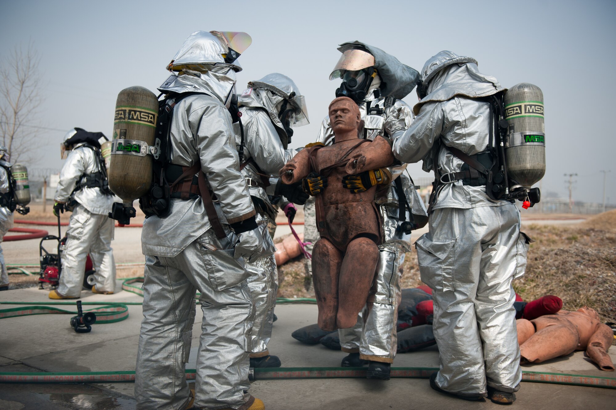 Firefighters from the 8th Civil Engineer Squadron fire department rescue ‘victims’ during a training scenario at Kunsan Air Base, Republic of Korea, Mar. 18, 2014. The firefighters conducted classroom and live-fire training with firefighters from Marine Wing Support Squadron 172 and the Republic of Korea air force 38th Fighter Group fire department to enhance teamwork between fire departments.  (U.S. Air Force photo by Staff Sgt. Clayton Lenhardt/Released)