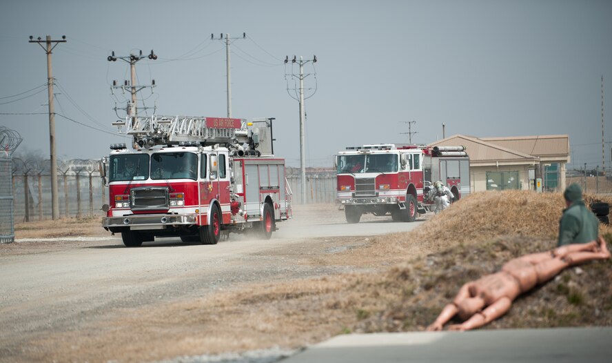 Firefighters from the 8th Civil Engineer Squadron fire department and Marine Wing Support Squadron 172 respond to a simulated fire at Kunsan Air Base, Republic of Korea, Mar. 18, 2014. The firefighters conducted classroom and live-fire training with the Republic of Korea air force 38th Fighter Group fire department to enhance teamwork between fire departments. (U.S. Air Force photo by Staff Sgt. Clayton Lenhardt/Released)