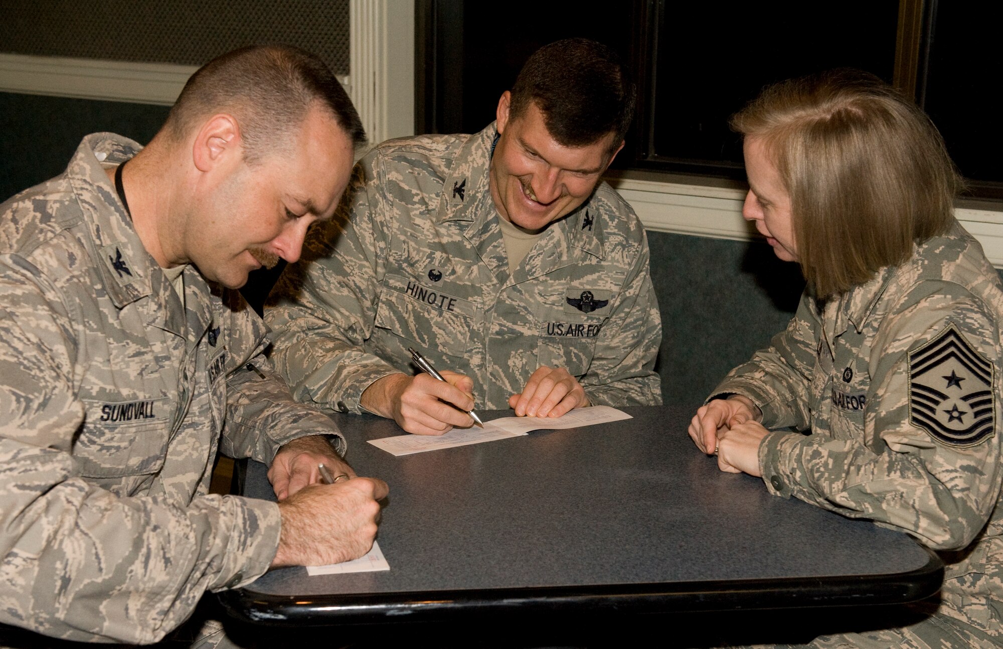 Colonel S. Clinton Hinote, 8th Fighter Wing commander (center), Col. Timothy Sundvall, 8th FW vice commander (left) and Chief Master Sgt. Rhonda Miller, 8th FW command chief, make their contributions to the Air Force Assistance Fund at Kunsan Air Base, Republic of Korea, Mar. 20, 2014. The AFAF was established to provide an annual effort to raise funds for the charitable affiliates providing support to Air Force families including in need active duty, retirees, reservists, guard and their dependents and surviving spouses. These organizations provide aid in an emergency, educational need or to have secure retirement housing for widows or widowers of Air Force members. (U.S. Air Force photo by Staff Sgt. Jessica Haas/Released)
