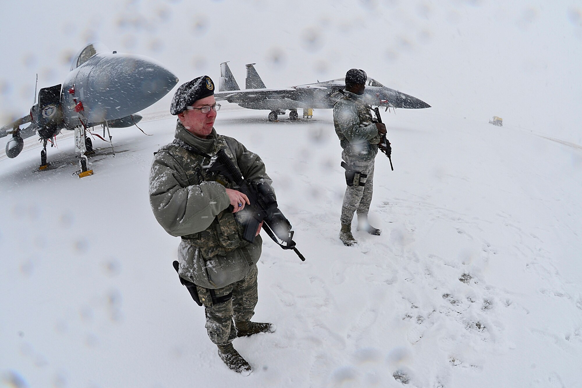 Airman 1st Class Codee Smith and Senior Airman Kadir Yusif, 48th Air Expeditionary Group response force members, stand guard on the flightline at Šiauliai Air Base, Lithuania March 17, 2014. The 48th Fighter Wing at Royal Air Force Lakenheath, England, sent an additional six aircraft and more than 50 personnel, to augment the four aircraft and approximately 150 Airmen already supporting NATO's ongoing air policing mission, at the request of U.S. allies in the Baltics. (U.S. Air Force photo by Airman 1st Class Dana J. Butler)