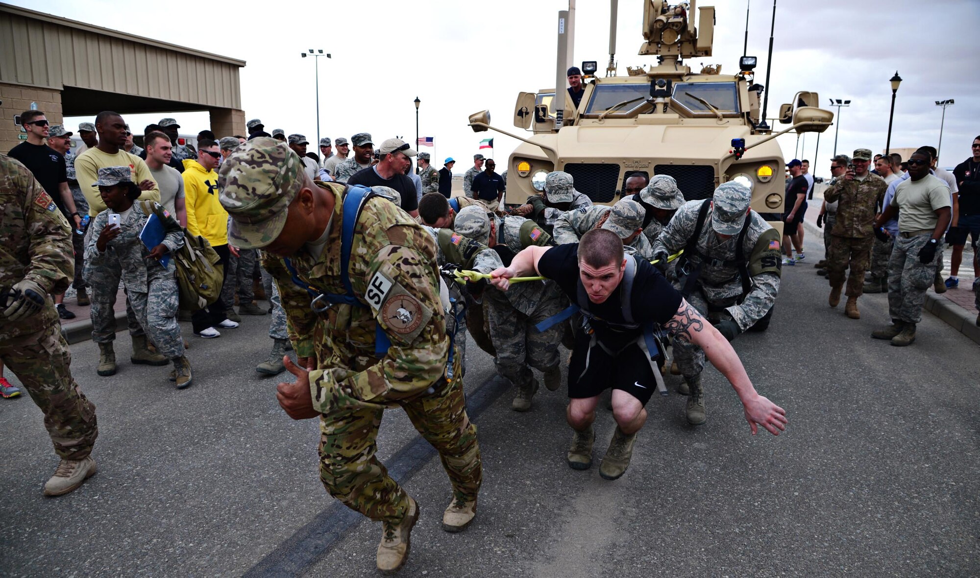 Security forces members dig deep to complete a mine-resistant, ambush-protected (MRAP) vehicle pull during the “Battle of the Badges”, at an undisclosed location in Southwest Asia. Fire Dogs and Defenders of the 386th Air Expeditionary Wing competed in the “Battle of the Badges” to commemorate their fallen comrades, build camaraderie through the units, and to celebrate their occupation. (U.S. Air Force photo by Senior Airman Desiree W. Moye)
