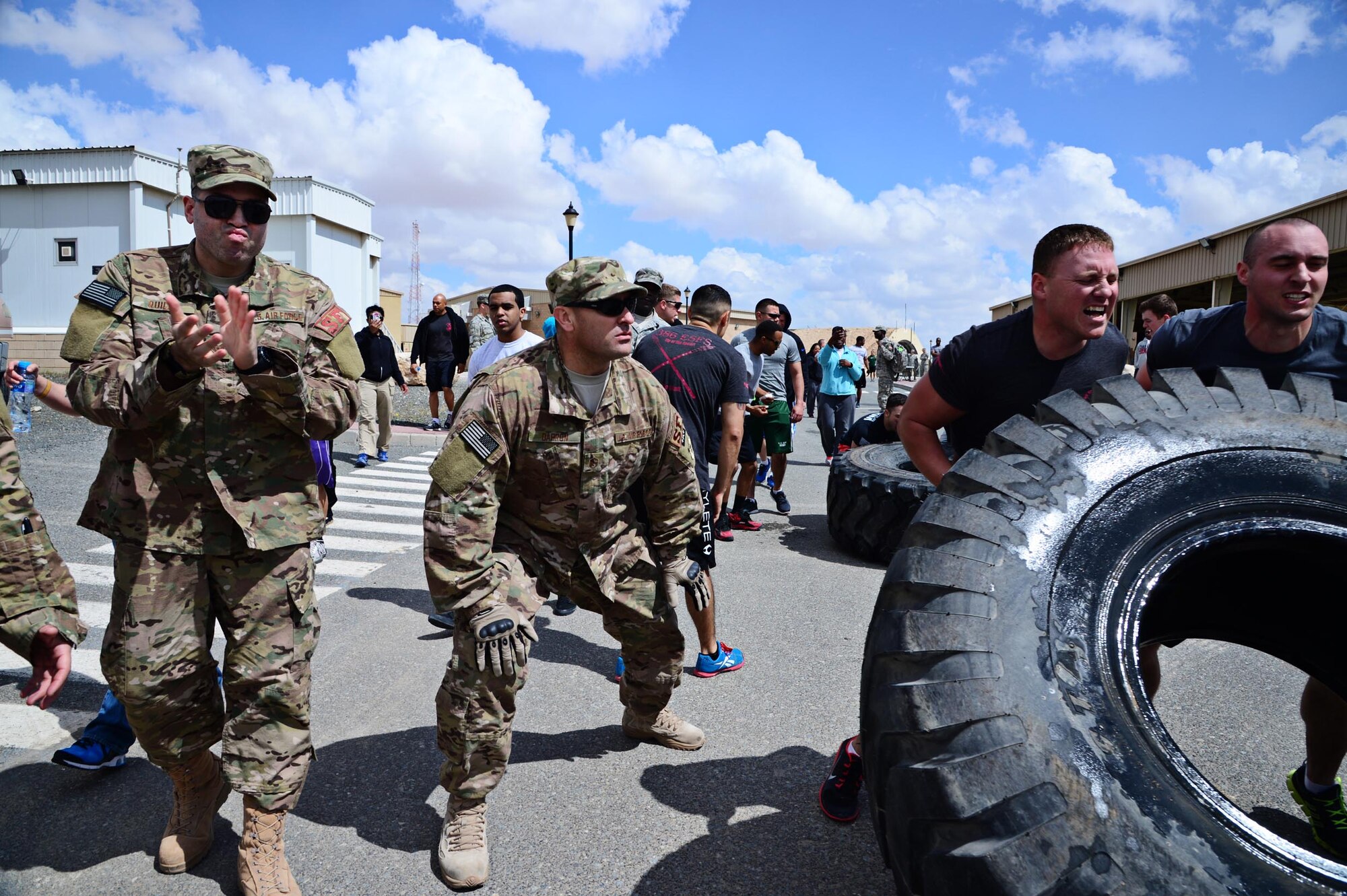 “Battle of the Badges” participants compete in a tire flip relay for the fastest time and bragging rights at an undisclosed location in Southwest Asia. Fire Dogs and Defenders of the 386th Air Expeditionary Wing competed in the “Battle of the Badges” to commemorate their fallen comrades, build camaraderie through the units, and to celebrate their occupation. (U.S. Air Force photo by Senior Airman Desiree W. Moye)