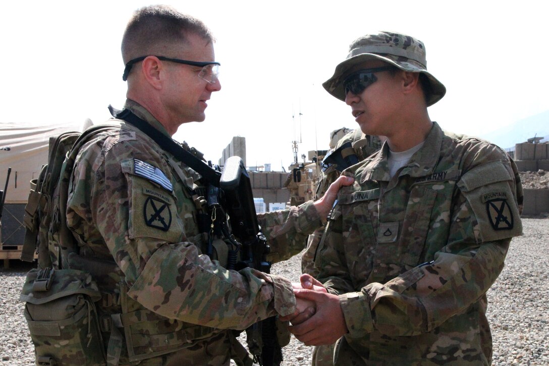 U.S. Army Col. Sam Whitehurst, left, awards U.S. Army Pfc. Shayneryan ...