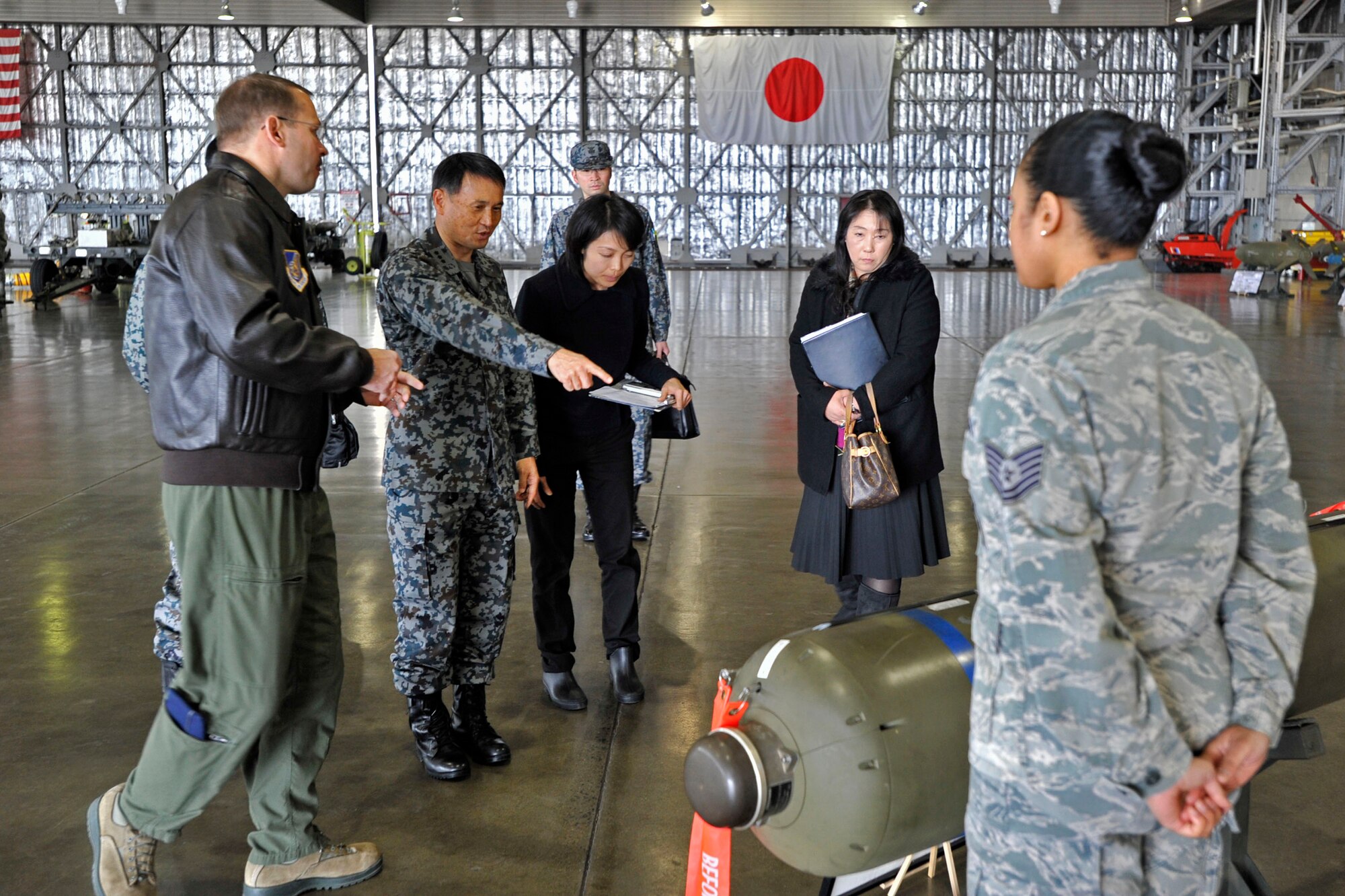 MISAWA AIR BASE, Japan -- Japan Air Self-Defense Force Lt. Gen. Tetsuo Morimoto, Northern Air Defense Force commander examines a cluster bomb with Col. Stephan Williams, 35th Fighter Wing commander, in Hangar 911, March 18, 2014. Williams was able to explain the payload capabilities of the F-16 Fighting Falcon to Morimoto, through NADF interpreter, Kumiko Kudo. (U.S. Air Force photo/Staff Sgt. Tong Duong)