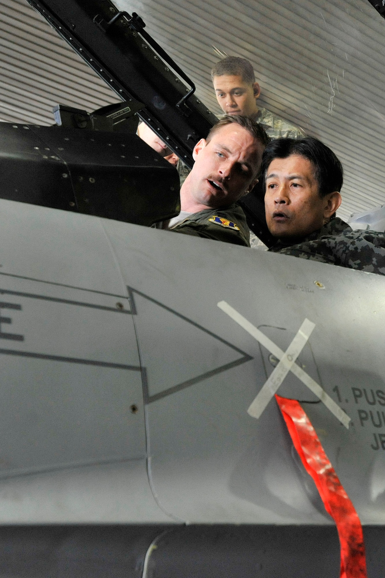 MISAWA AIR BASE, Japan -- Japan Air Self-Defense Force Maj. Gen. Shigeki Nakahara, Northern Aircraft Control and Warning Wing commander, receives a demonstration of an F-16 Fighting Falcon targeting pod, from U.S. Air Force Capt. Miklos Preysz, 14th Fighter Squadron pilot, in Hangar 911, March 18, 2014. With every Airman overseas an American ambassador, showcasing our warfighters helps to strengthen U.S. and Japanese alliances, partnerships and shared theater security. (U.S. Air Force photo/Staff Sgt. Tong Duong)