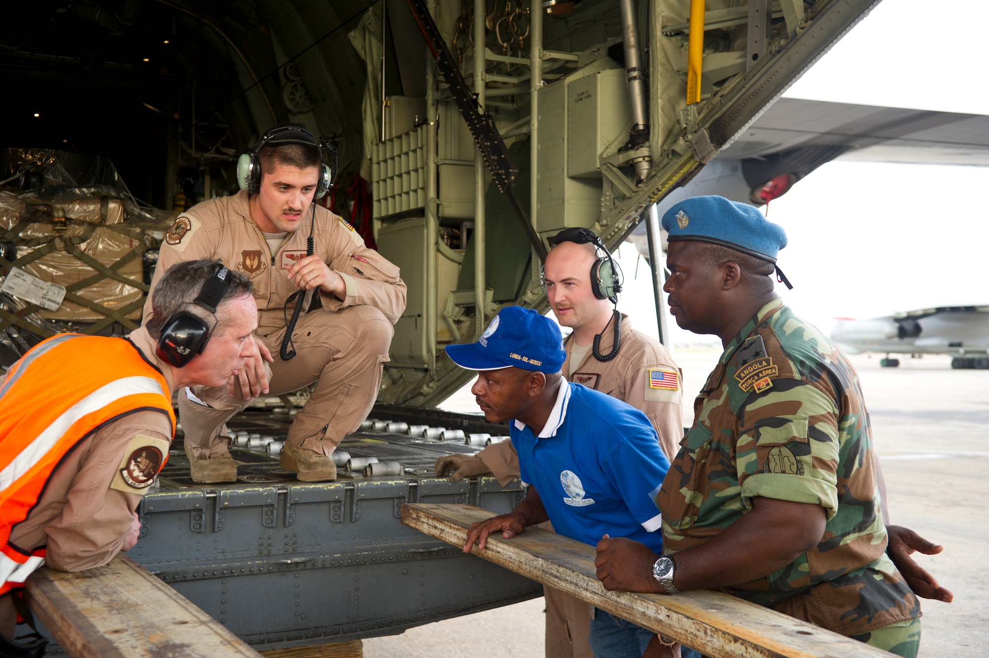 U.S. and Angolan airmen discuss unloading a C-130J Super Hercules from the 37th Airlift Squadron at Luanda Air Base, Angola, March 22, 2014. The C-130J and about 20 U.S. Air Force airmen are in Angola to participate in African Partnership Flight with the Angolan and Zambian air forces, an event which provides a collaborative learning environment for the airmen. (U.S. Air Force photo/Tech. Sgt. Benjamin Wilson)