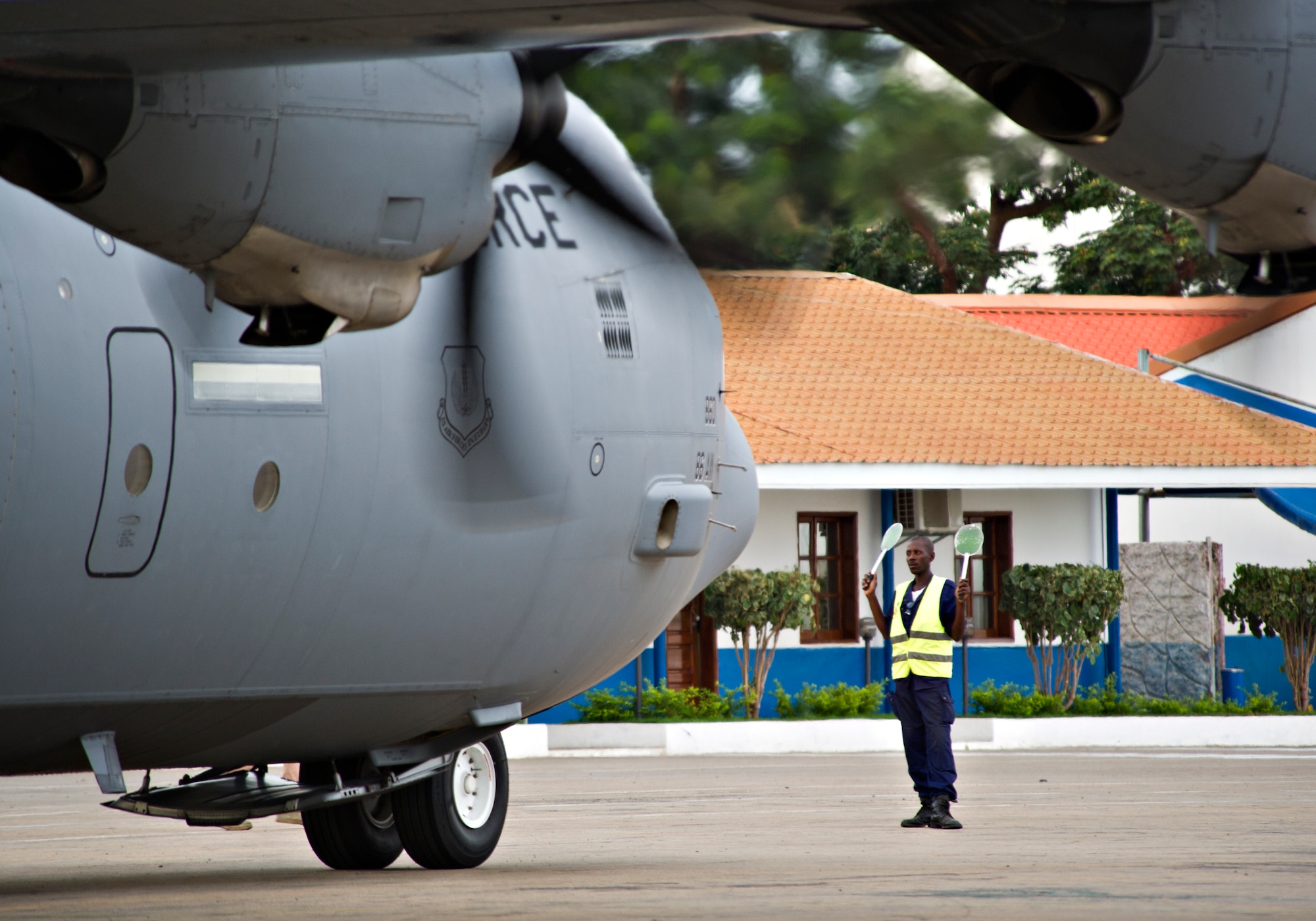 Angolan air force Cpl. Joaquim Francise marshals a U.S. Air Force C-130J Super Hercules from the 37th Airlift Squadron at Luanda Air Base, Angola, March 22, 2014. More than 20 U.S. Air Force airmen arrived to participate in African Partnership Flight with the Angolan and Zambian air forces, an event which provides a collaborative learning environment for the airmen. (U.S. Air Force photo/Tech. Sgt. Benjamin Wilson)