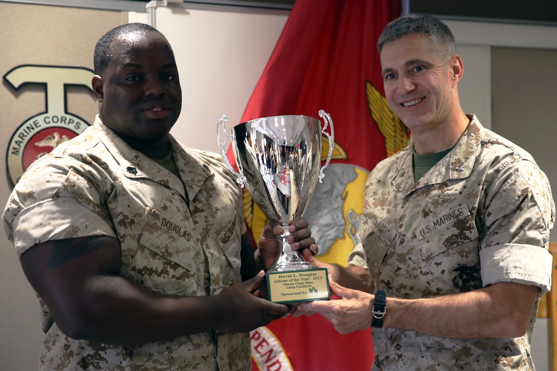Brig. Gen. John W. Bullard presents Sgt. David Douglas with the Male Athlete of the Year Award for his success in his powerlifting competitions March 20 in the Commanding General's conference room. Douglas has eight state records, five American records and is currently ranked as the number one 308lb power lifter in the country.  Bullard is the commanding general of Marine Corps Installations West-Marine Corps Base Camp Pendleton.