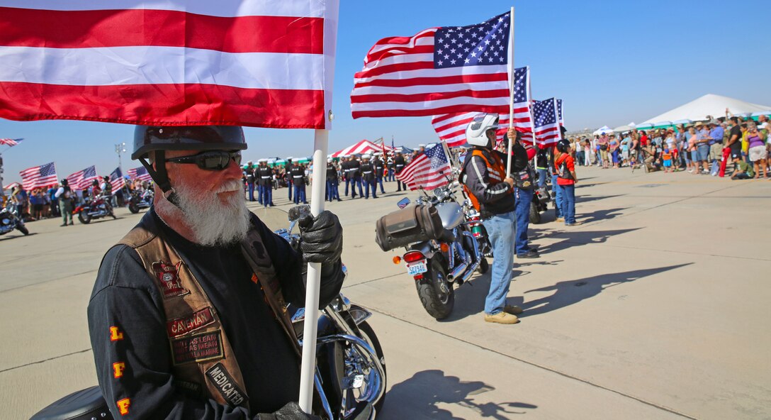 Reg Amell (left), who retired after a combined 28 years of service in the United States Air Force, U.S. Army, U.S. Marine Corps and U.S. Merchant Marines, stands his post at Marine Corps Air Station Yuma, Ariz., as part of the Patriot Guard Riders opening ceremony for the  52nd Annual Yuma Airshow, March 15. The non-profit veterans support organization filed out and presented a flag line in honor of fallen veterans and active-duty service members. (Photo by Cpl. Uriel Avendano)