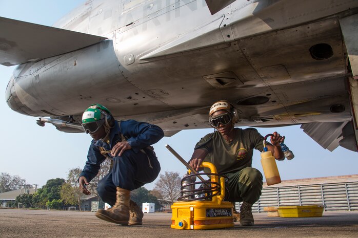 Lance Cpl. Michael Hines, left, and Cpl. Terrence Watts insert engine oil into an FA-18D Hornet aboard Wing One Royal Thai Air Force Base, Nakhon Ratchasima, Kingdom of Thailand, during a preflight check Feb. 20 during Exercise Cobra Gold 2014. CG 14 is a joint, multinational exercise conducted annually in the Kingdom of Thailand aimed at enhancing and increasing multinational interoperability. The Marines and FA-18D Hornet aircraft are with Marine All Weather Fighter Attack Squadron 242, Marine Aircraft Group 12, 1st Marine Aircraft Wing, III Marine Expeditionary Force.