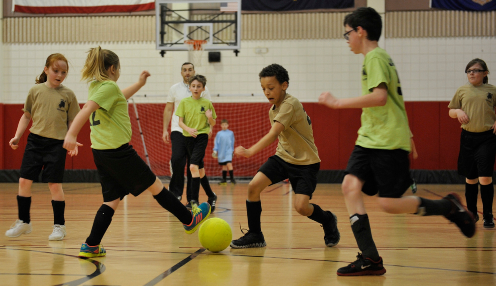 Devin King, 9, center, son of Sgt. 1st Class Lisa King, Headquarters and Headquarters Company, 17th Combat Sustainment Support Battalion, defends against the Green Dragons during a youth soccer game at the Kennecott Youth Center on Joint Base Elmendorf-Richardson, Alaska, March 17, 2014. The youth centers on JBER host youth sports as part of military and family readiness and morale. (U.S. Air Force photo/Airman 1st Class Tammie Ramsouer)