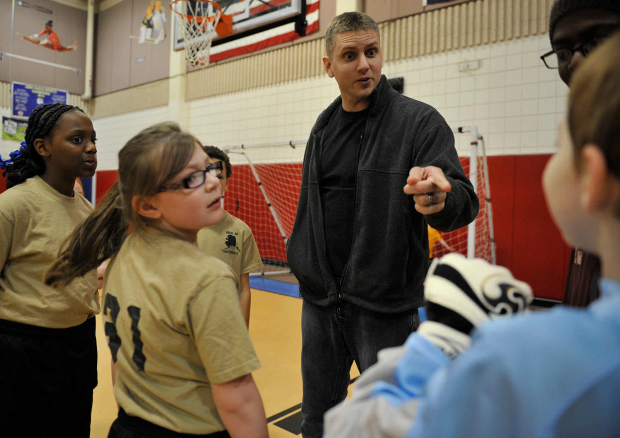 Air Force Staff Sgt. William Banton, 673d Air Base Wing public affairs, motivates the Exploding Creepers players during a youth soccer game at the Kennecott Youth Center on Joint Base Elmendorf-Richardson, Alaska, March 17, 2014. The youth centers on JBER host youth sports as part of military and family readiness and morale. (U.S. Air Force photo/Airman 1st Class Tammie Ramsouer)