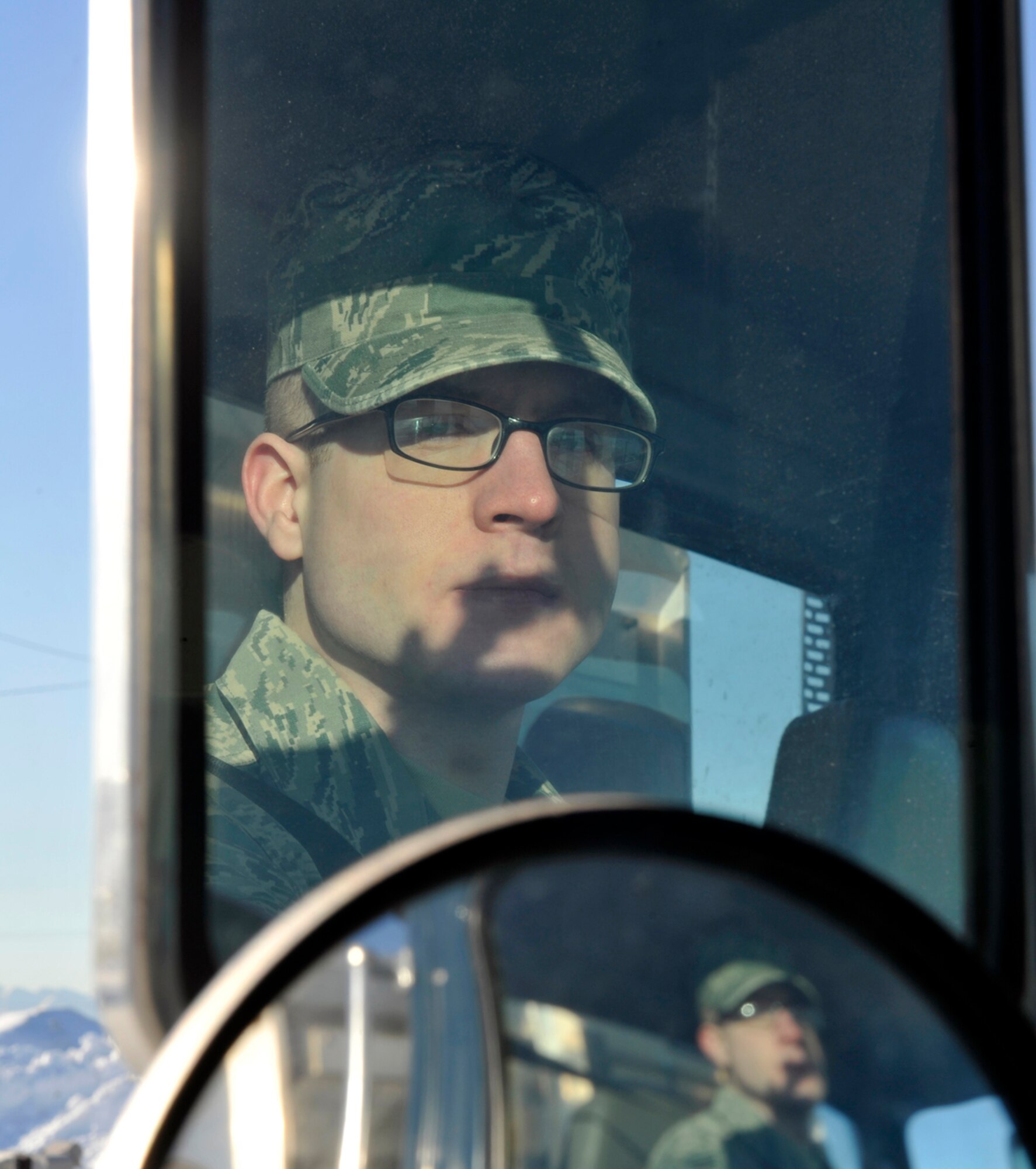 Senior Airman Andrew Schoon checks his mirrors while driving a seven-and-a-half-ton tractor on Joint Base Elmendorf-Richardson, Alaska, March 20, 2014. Schoon is a vehicle operator/dispatcher for the 773d Logistics Readiness Squadron. Schoon is the second active-duty member to be selected for Tops in Blue on JBER. Airman 1st Class Alexander Ross, the 673rd Logistic Readiness Squadron fuels technician, also earned the opportunity. (U.S. Air Force photo/Airman 1st Class Tammie Ramsouer)