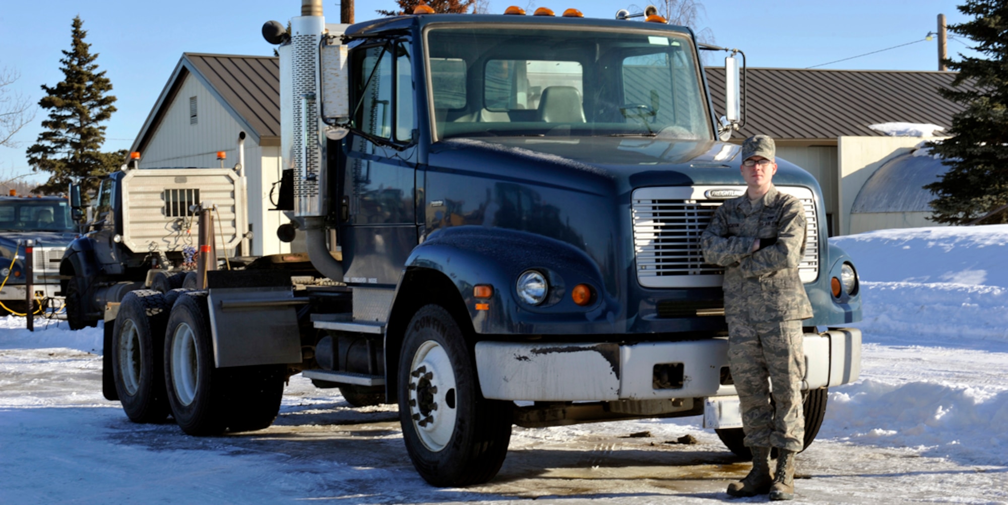 Senior Airman Andrew Schoon, a vehicle operator/dispatcher for the 773d Logistics Readiness Squadron, stands in front of a tractor on Joint Base Elmendorf-Richardson, Alaska, March 20, 2014. Schoon earned a position in this year’s Tops in Blue to be a crew member for the 10 month tour. Tops and Blue has been recruiting active duty Air Force members for shows to become performers and crew members during yearly 10 month tours for more than 60 years. (U.S. Air Force photo/Airman 1st Class Tammie Ramsouer)