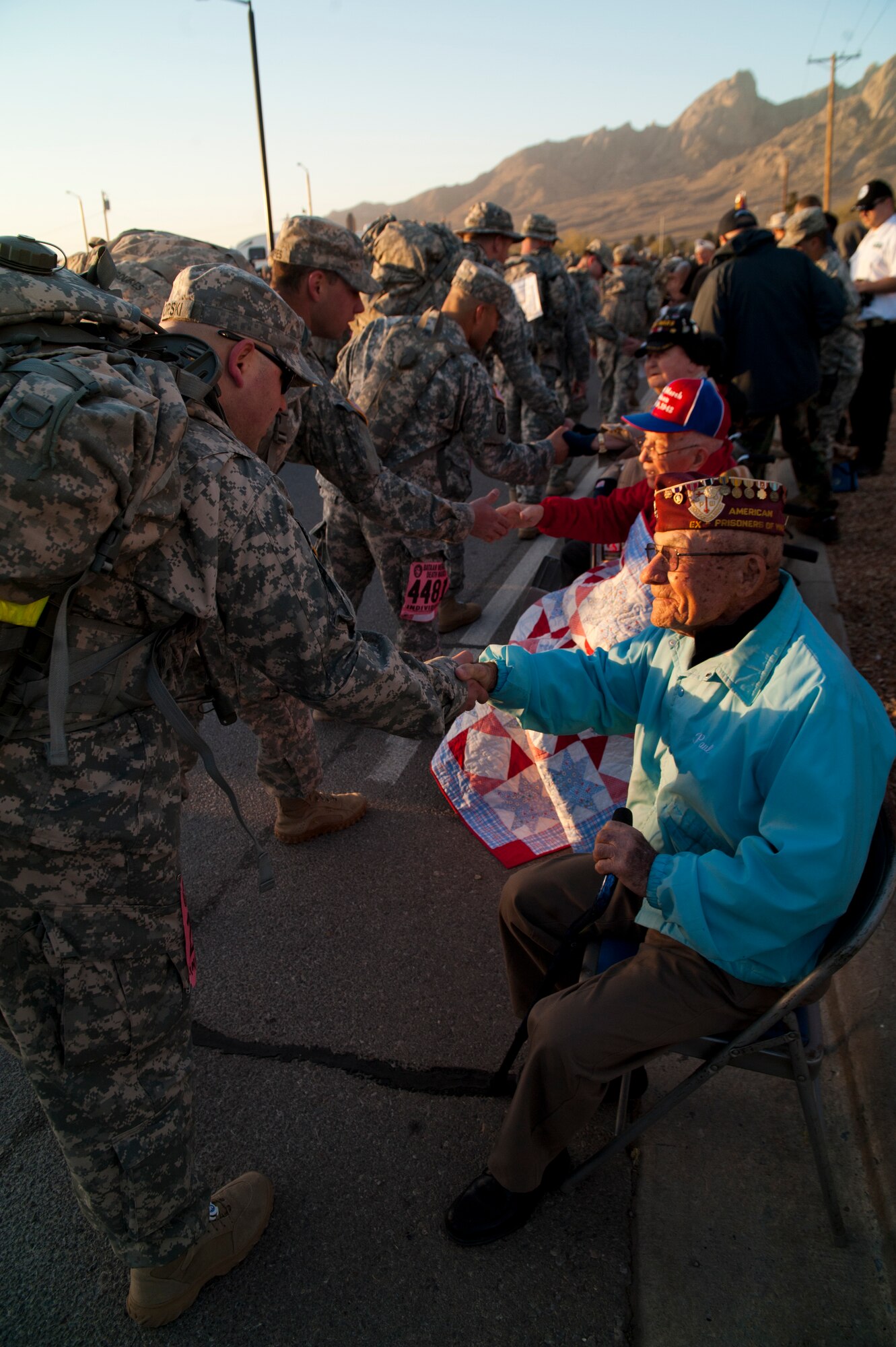 Survivors of the Bataan Death March shake hands of participants during the commencement of the Bataan Memorial Death March at White Sands Missile Range, N.M., March 23. Over 6,200 participants came to honor more than 76,000 Prisoners of War and Missing in Action from Bataan and Corregidor during World War II. The 26.2-mile course starts on WSMR, enters hilly terrain and finishes through sandy desert trails, with elevation ranging from 4,100 to 5,300 feet. (U.S. Air Force photo by Airman 1st Class Aaron Montoya / Released)