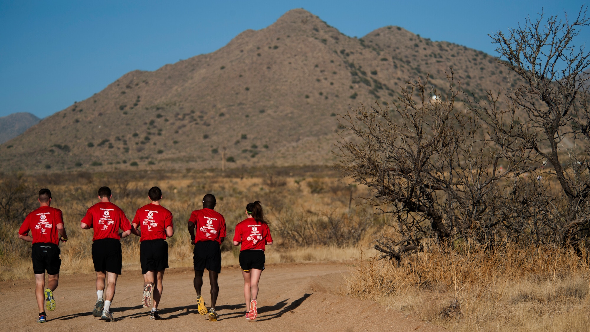 A team of participants in the 25th annual Bataan Memorial Death March make their way through the course at White Sands Missile Range, N.M., March 23. Over 6,200 participants came to honor more than 76,000 Prisoners of War and Missing in Action from Bataan and Corregidor during World War II. The 26.2-mile course starts on WSMR, enters hilly terrain and finishes through sandy desert trails, with elevation ranging from 4,100 to 5,300 feet. (U.S. Air Force photo by Airman 1st Class Aaron Montoya / Released)