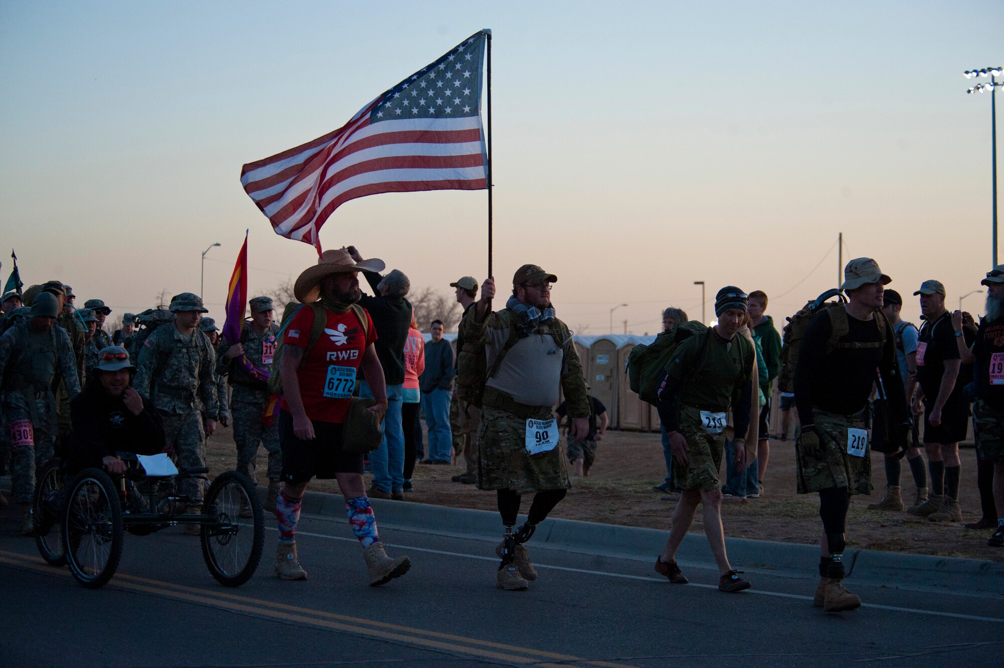 Participants in the Bataan Memorial Death March salute the flag as the White Sands Missile Range honor guard posts the colors during the opening ceremony at White Sands Missile Range, N.M., March 23. Over 6,200 participants came to honor more than 76,000 Prisoners of War and Missing in Action from Bataan and Corregidor during World War II. The 26.2-mile course starts on WSMR, enters hilly terrain and finishes through sandy desert trails, with elevation ranging from 4,100 to 5,300 feet. (U.S. Air Force photo by Airman 1st Class Aaron Montoya / Released)