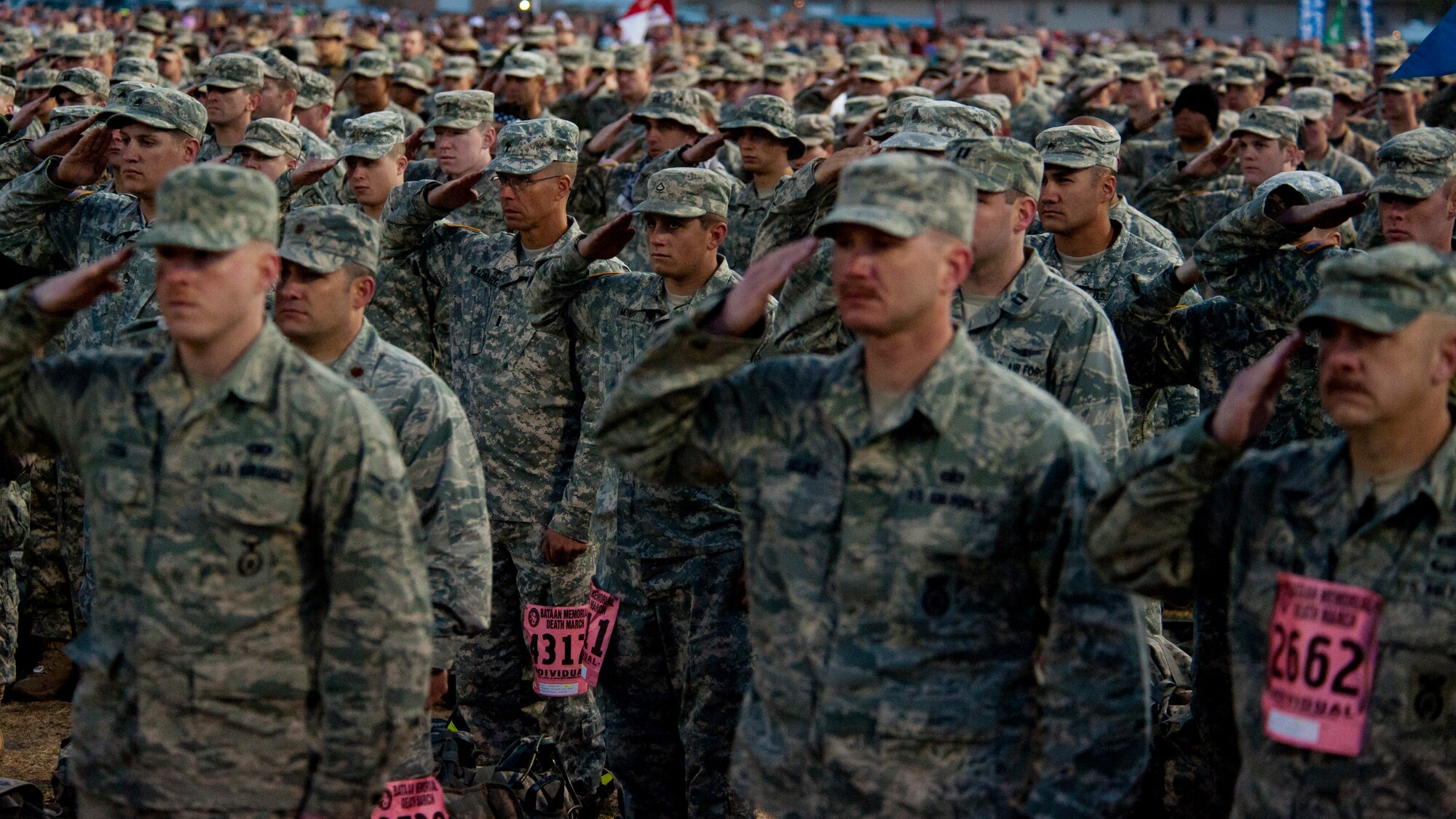Participants in the Bataan Memorial Death March salute the flag as the White Sands Missile Range honor guard posts the colors during the opening ceremony at White Sands Missile Range, N.M., March 23. Over 6,200 participants came to honor more than 76,000 Prisoners of War and Missing in Action from Bataan and Corregidor during World War II. The 26.2-mile course starts on WSMR, enters hilly terrain and finishes through sandy desert trails, with elevation ranging from 4,100 to 5,300 feet. (U.S. Air Force photo by Airman 1st Class Aaron Montoya / Released)