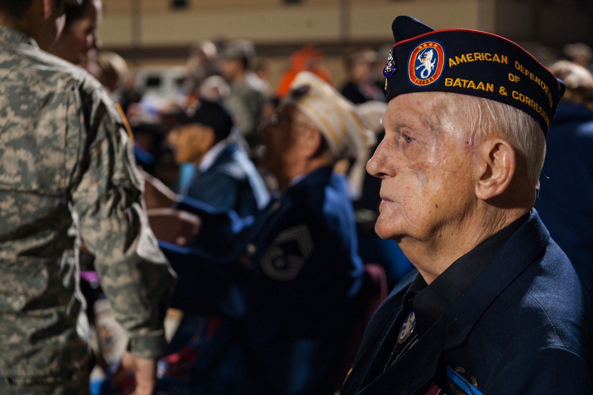 Retired U.S. Army Master Sgt. William Eldridge, greets guests and answers questions during the opening ceremony of the Bataan Memorial Death March at White Sands Missile Range, N.M, March 23. Over 6,200 participants came to honor more than 76,000 Prisoners of War and Missing in Action from Bataan and Corregidor during World War II. The 26.2-mile course starts on WSMR, enters hilly terrain and finishes through sandy desert trails, with elevation ranging from 4,100 to 5,300 feet. (U.S. Air Force photo by Airman 1st Class Aaron Montoya / Released)