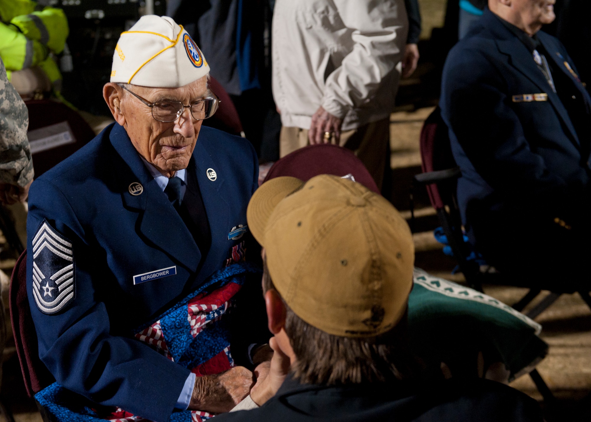 Retired U.S. Air Force Chief Master Sgt. Harold Bergbower, greets guests and answers questions during the opening ceremony of the Bataan Memorial Death March at White Sands Missile Range, N.M, March 23. Over 6,200 participants came to honor more than 76,000 Prisoners of War and Missing in Action from Bataan and Corregidor during World War II. The 26.2-mile course starts on WSMR, enters hilly terrain and finishes through sandy desert trails, with elevation ranging from 4,100 to 5,300 feet. (U.S. Air Force photo by Airman 1st Class Aaron Montoya / Released)