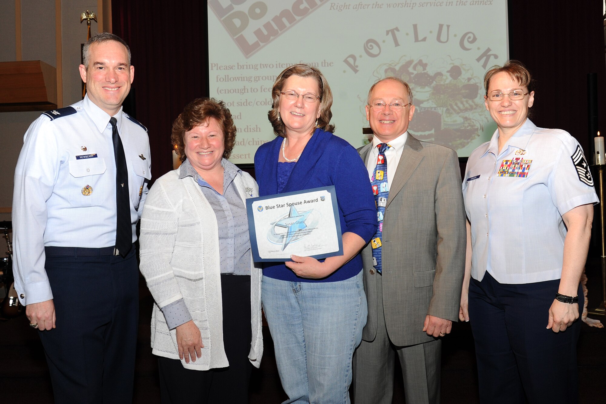 Col. Brian Newberry, the 92nd Air Refueling Wing commander, his wife, Jill, Chief Master Sgt. Wendy Hansen, the 92nd ARW command chief, and Chaplain (Lt. Col.) James Glass, 92nd ARW, present the Blue Star Spouse Award to Susan Glass, the chaplain's wife, at Fairchild Air Force Base, Wash., March 24, 2014. For nearly four years, Mrs. Glass' countless volunteer hours, her vital services representing the Officers Spouses Club at base events or supporting Faichild's medics' family support group as well as her selfless initiatives coordinating an amazing amount of meals for families in need made the entire wing family stronger. Anyone interested in nominating someone for the Blue Star Spouse Award should contact their squadron commander. (U.S. Air Force photo by Airman 1st Class Janelle Patiño/Released)