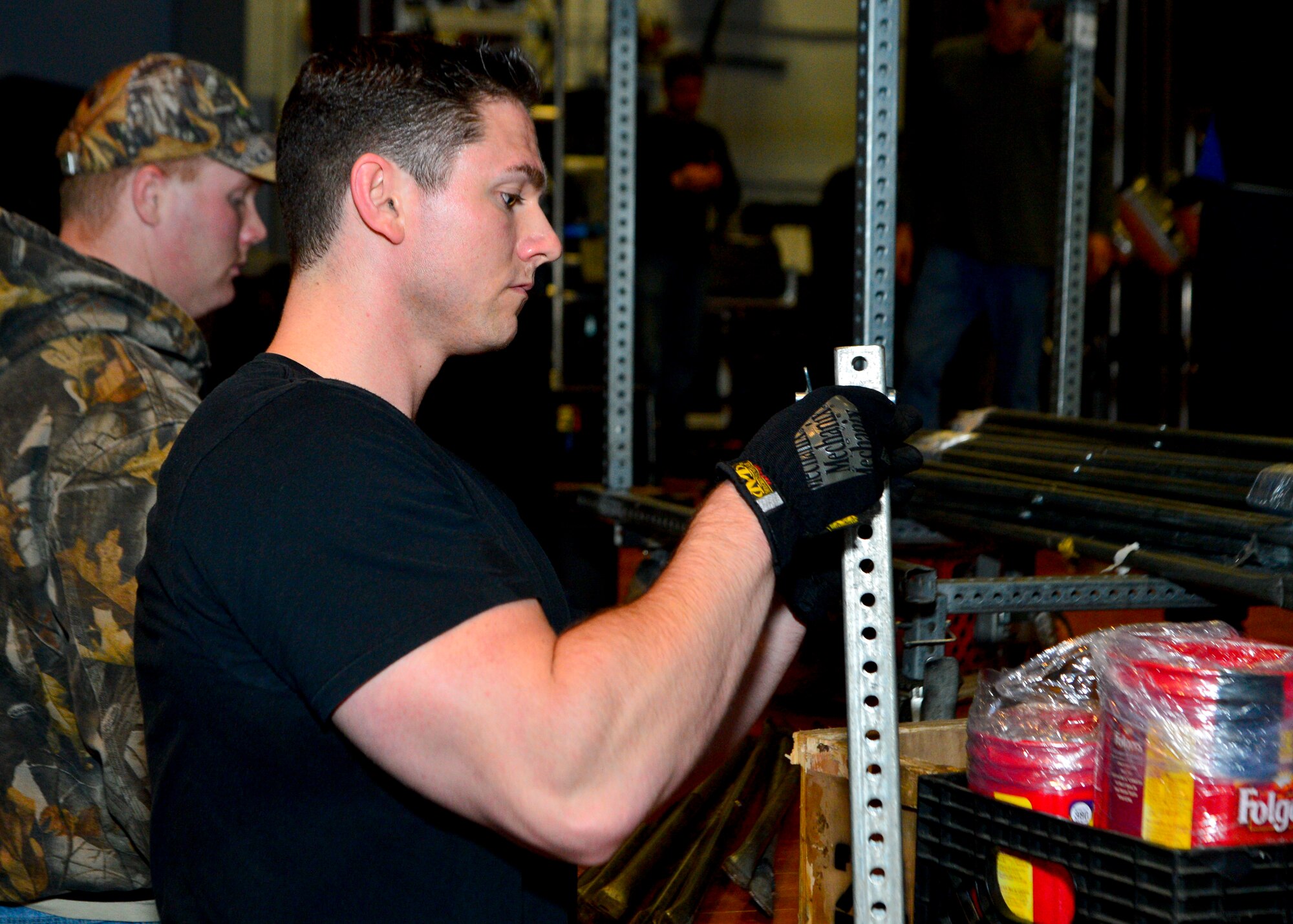 Staff Sgt. Zach Sielaff, 436th Civil Engineer Squadron firefighter, dismantles scaffolding during the teardown of the lighting, sound, and musical equipment March 19, 2014, inside the base theater on Dover Air Force Base, Del. The scaffolding was used to hold up a platform on which a drum set was setup. (U.S. Air Force photo/Airman 1st Class Zachary Cacicia)
