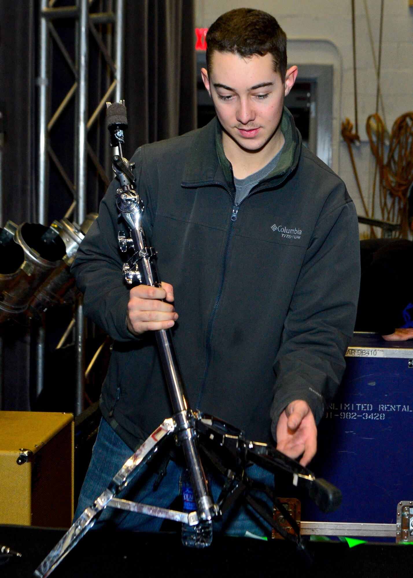 Airman 1st Class Carl Townsend, 436th Aircraft Maintenance Squadron aerospace propulsion, dismantles a drum kit during the teardown of the lighting, sound, and musical equipment March 19, 2014, inside the base theater on Dover Air Force Base, Del. The equipment was used during a Jana Kramer and Swon Brothers concert hosted by the USO. (U.S. Air Force photo/Airman 1st Class Zachary Cacicia) 