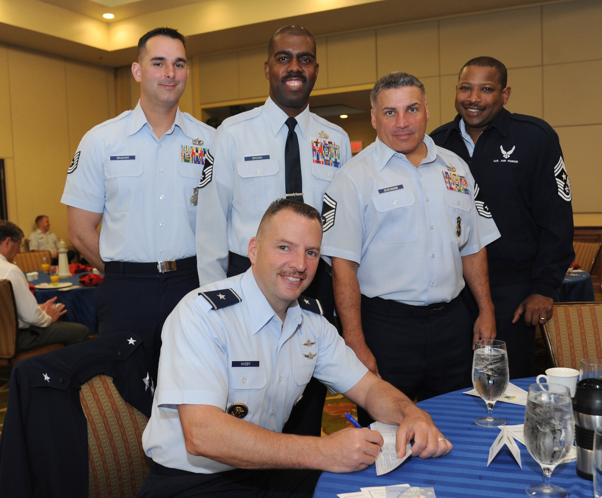 Brig. Gen. Patrick Higby, 81st Training Wing commander, prepares to complete an Air Force Assistance Fund form as Tech. Sgt. Vincent Brasher, 81st Security Forces Squadron; Senior Master Sgts. Isaac Brown, 81st Training Support Squadron, and Robert DeGennaro, 81st SFS, and Chief Master Sgt. Farrell Thomas, 81st TRW command Chief, stand behind during the AFAF kickoff breakfast March 24, 2014, at the Bay Breeze Event Center, Keesler Air Force Base, Miss. AFAF lends critical support to active duty and retired Airmen and their families.  Brasher, Brown and DeGennaro are the project managers for the 81st Training Wing.  (U.S. Air Force photo by Kemberly Groue)