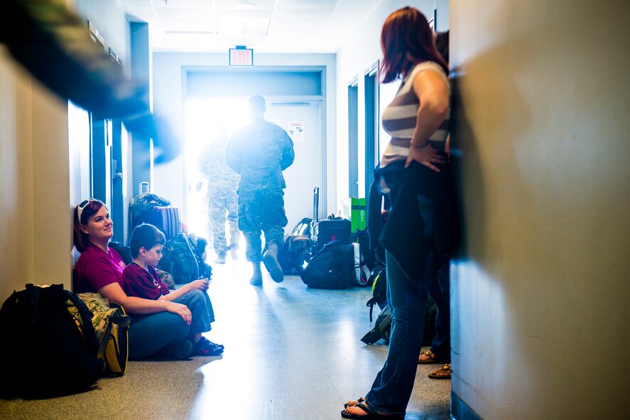 Amber Seigler (left), with her son, Aaron, speaks with Alexa Singer as deployers walk to and from the flightline March 21, 2014, at Moody Air Force Base, Ga. The two are wives of U. S. Air Force Staff Sgt. Joseph Seigler and 1st Lt. Bryan Singer, two Airmen from the 71st Rescue Squadron who departed with what is planned to be the last two active-duty HC-130P Combat Kings to deploy downrange. (U.S. Air Force photo by Staff Sgt. Jamal D. Sutter/Released)