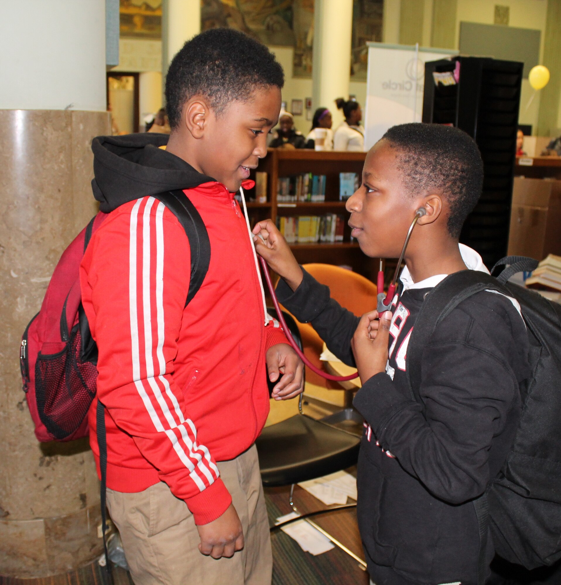 Chris listens to Davon’s heartbeat during a health fair Feb. 26, 2014, at Lift for Life Academy, where both are sixth grade students. Service members from Scott Air Force Base, Ill., manned information stations, talked about fitness, discussed resiliency and demonstrated Self Aid Buddy Care techniques to the students. (Courtesy photo/Katelyn Hippen-Smith)