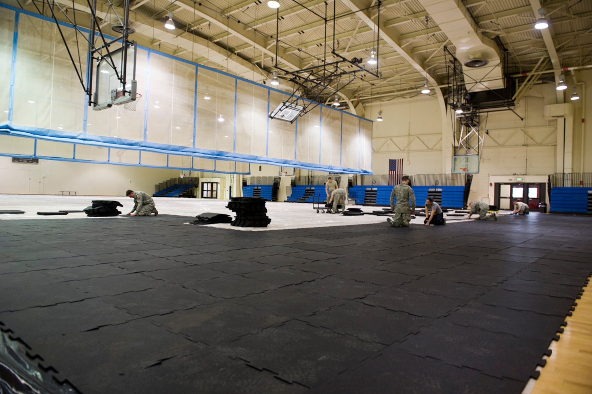 Volunteers from many units of Joint Base Elmendorf-Richardson units prepare temporary living quarters on the basketball court of the JBER-Elmendorf Fitness Center on JBER, Alaska, March 17, 2014 for exercise Alaska Shield. Airmen prepared spaces in JBER fitness facilities for more than 500 participants. (U.S. Air Force photo/Airman 1st Class Omari Bernard)