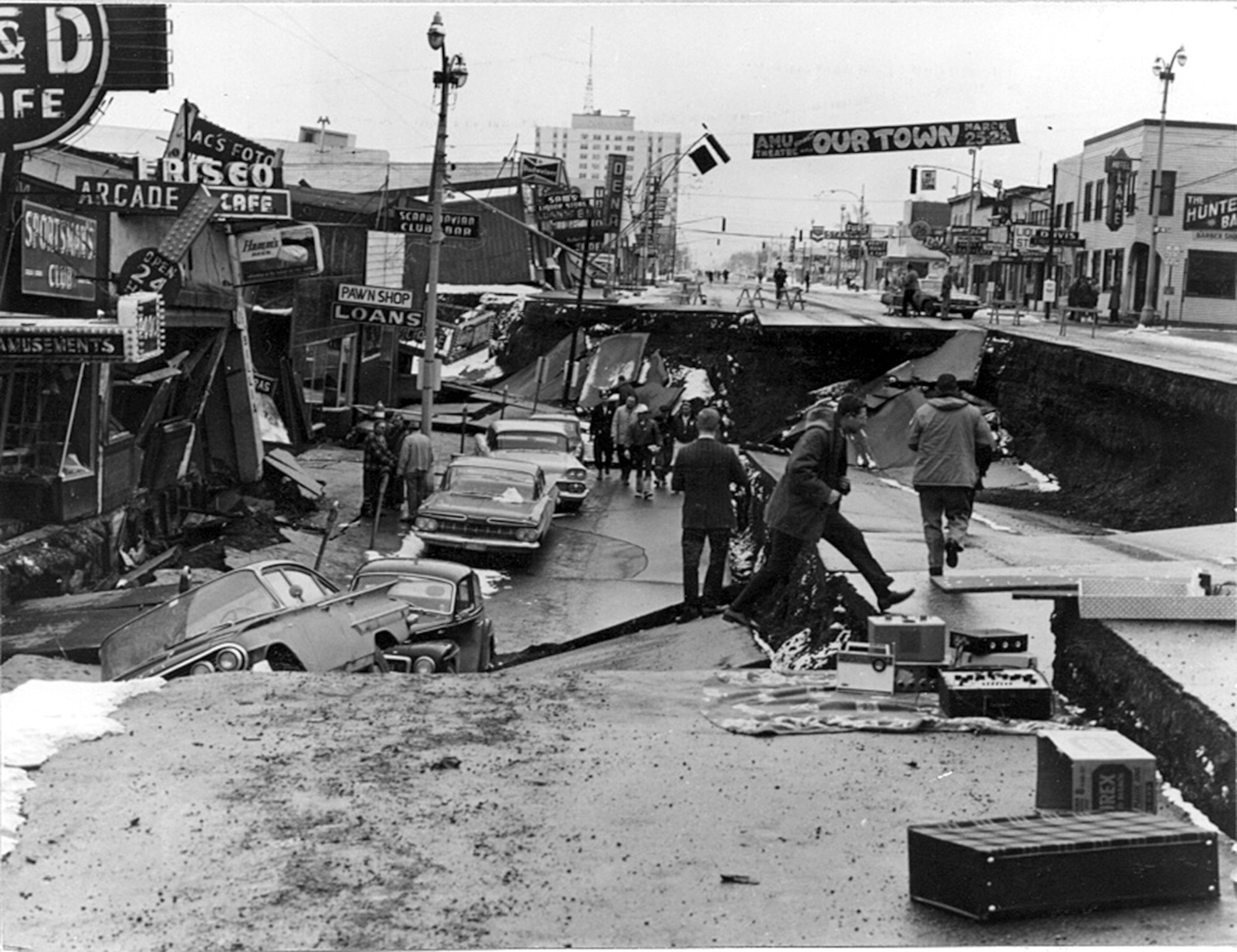 Alaska Earthquake March 27, 1964. Collapse of Fourth Avenue near C Street in Anchorage due to a landslide caused by the earthquake. Before the shock, the sidewalk on the left, which is in the graben, was at street level on the right. The graben subsided 11 feet in response to 14 feet of horizontal movement. (Photo by U.S. Army)