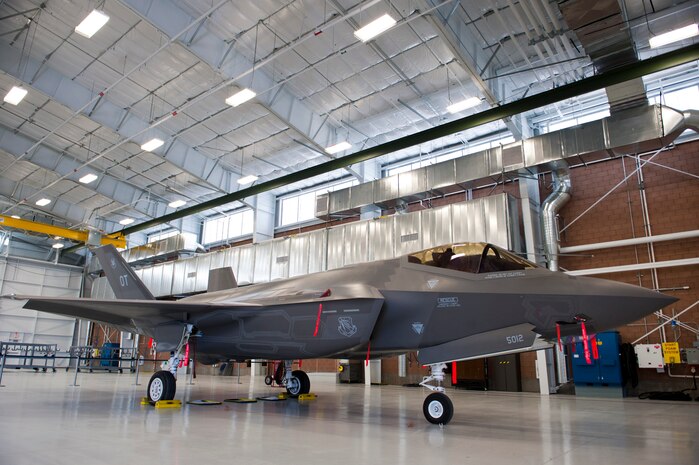 A U.S. Air Force F-35 Lightning II sits on display in the new Lightning Aircraft Maintenance Unit hangar  March 18, 2014, at Nellis Air Force Base, Nev. The new hangar  will also have an engine maintenance addition built into the facility. Engine maintenance will now be conducted in the same facility the aircraft is stored in. Not moving an engine from one facility to another will make maintenance more efficient and ultimately reduce the amount of time the aircraft must remain on the ground. (U.S. Air Force photo by Airman 1st Class Thomas Spangler)