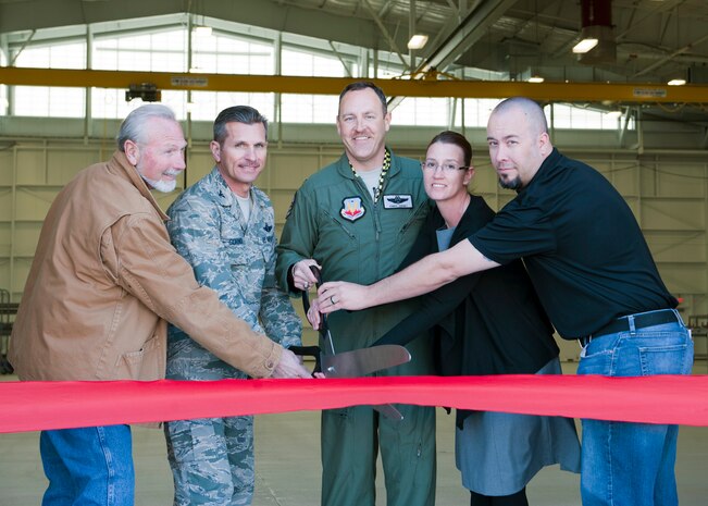 Straub Construction Inc. superintendent Bob Hughes (left), U.S. Air Force Col. Barry Cornish, 99th Air Base Wing commander, (second from left), Col. Christopher Short 57th Wing commander (center), quality control manager Michelle Hanks (second from right) and Straub project manager Steve Zohner (right), prepare to cut the ribbon for the new F-35 Lightning Aircraft Maintenance Unit hangar March 18, 2014, at Nellis Air Force Base, Nev. The new hanger is a state-of-the-art maintenance facility that will ease the operations and improve maintenance efficiency of the F-35 Lightning II. (U.S. Air Force photo by Airman 1st Class Thomas Spangler)