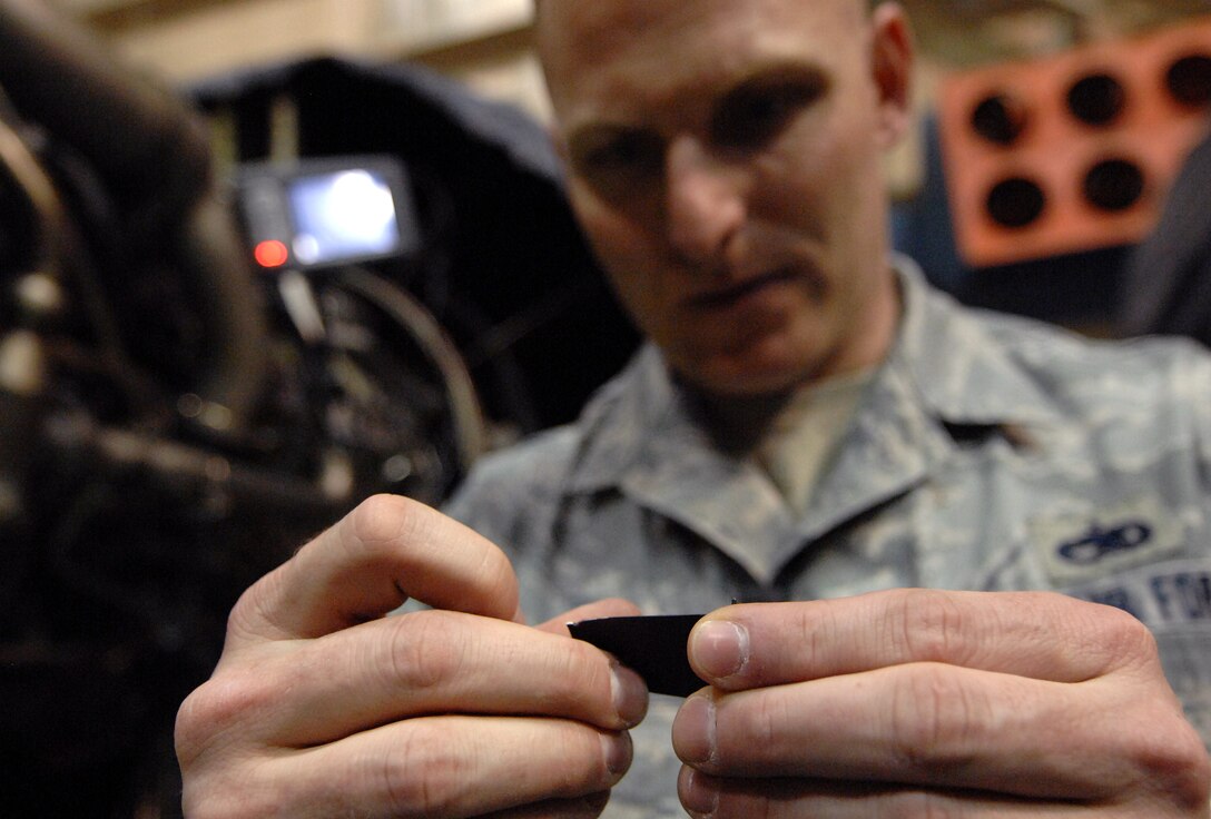 Master Sgt. Steve Pakusch, 55th Aerospace Maintenance Squadron production superintendent, inspects a compressor blade after using a Wolf Blending Scope to grind down irregularities caused by foreign object damage inside an aircraft hangar at Offutt Air Force Base, Neb. March 19. (U.S. Air Force photo by Delanie Stafford/Released)