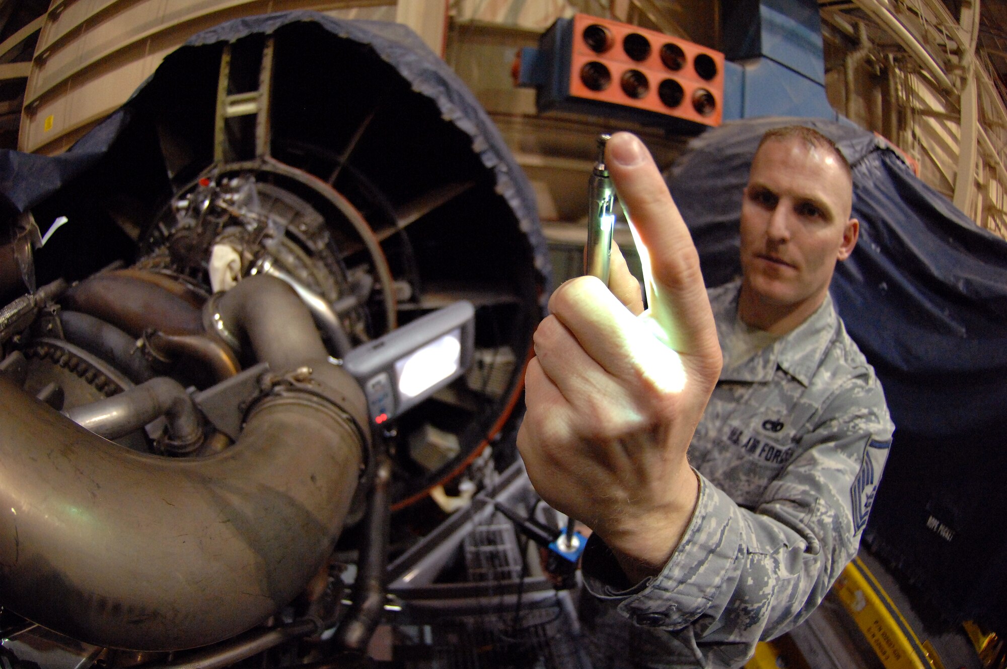 Master Sgt.  Steve Pakusch, 55th Aerospace Maintenance Squadron production superintendent, explains how the Wolf Blending Scope works inside an aircraft hangar at Offutt Air Force Base, Neb. March 19. An adjustable grinding tool attached to a rod about three feet long can be inserted through a one-inch port on the side of an aircraft engine, which allows Pakusch to grind down irregularities without removing the engine from the aircraft and taking it apart. A light on the end of the scope along with a camera provide a high quality video feed to an external monitor, necessary for the repairs. (U.S. Air Force photo by Delanie Stafford/Released)